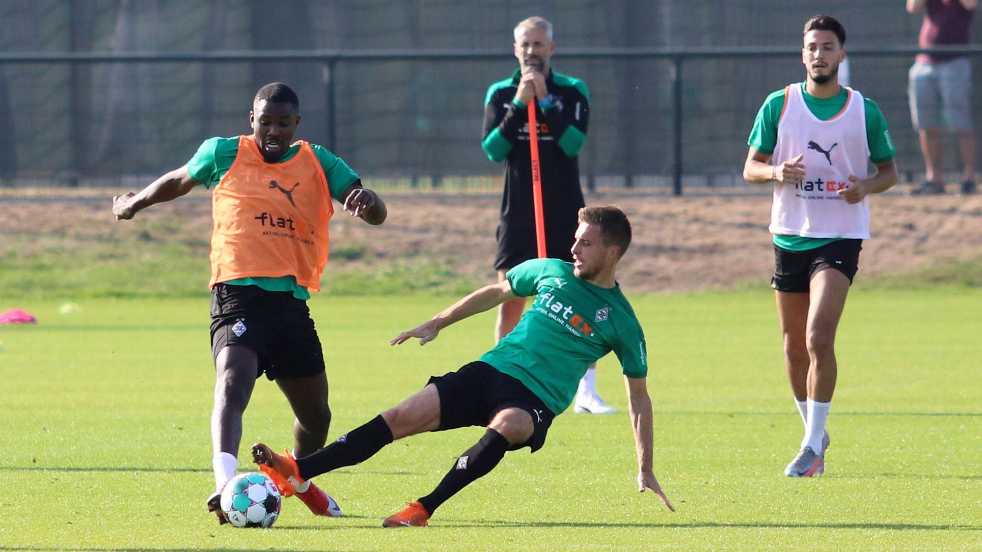 Marcus Thuram (l.) wird von Patrick Herrmann abgegrätscht.