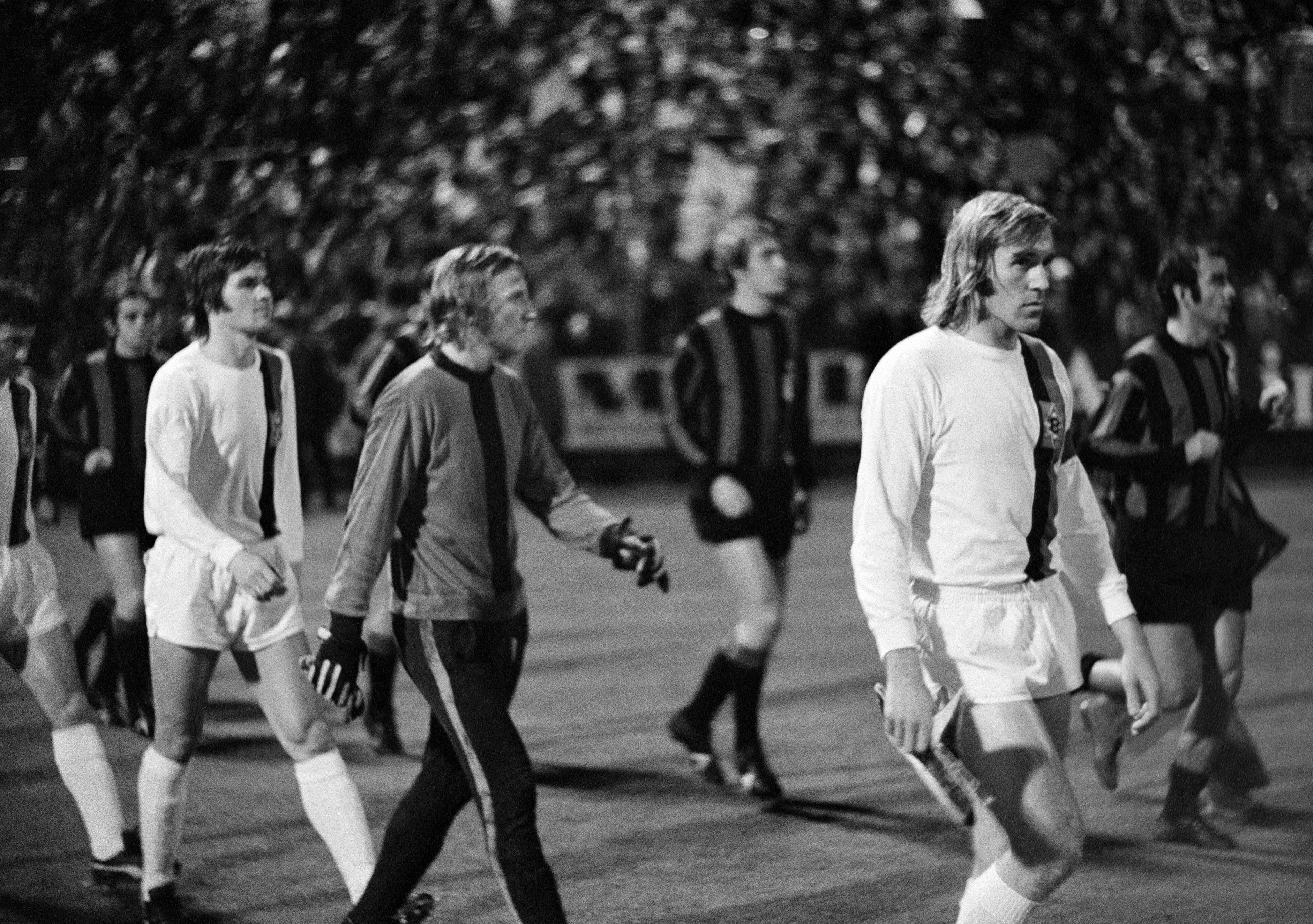Ulrik Le Fevre (l.), Wolfgang Kleff (m.) und Günter Netzer (r.) laufen zum legendären Gladbacher „Büchsenwurfspiel” ein.
