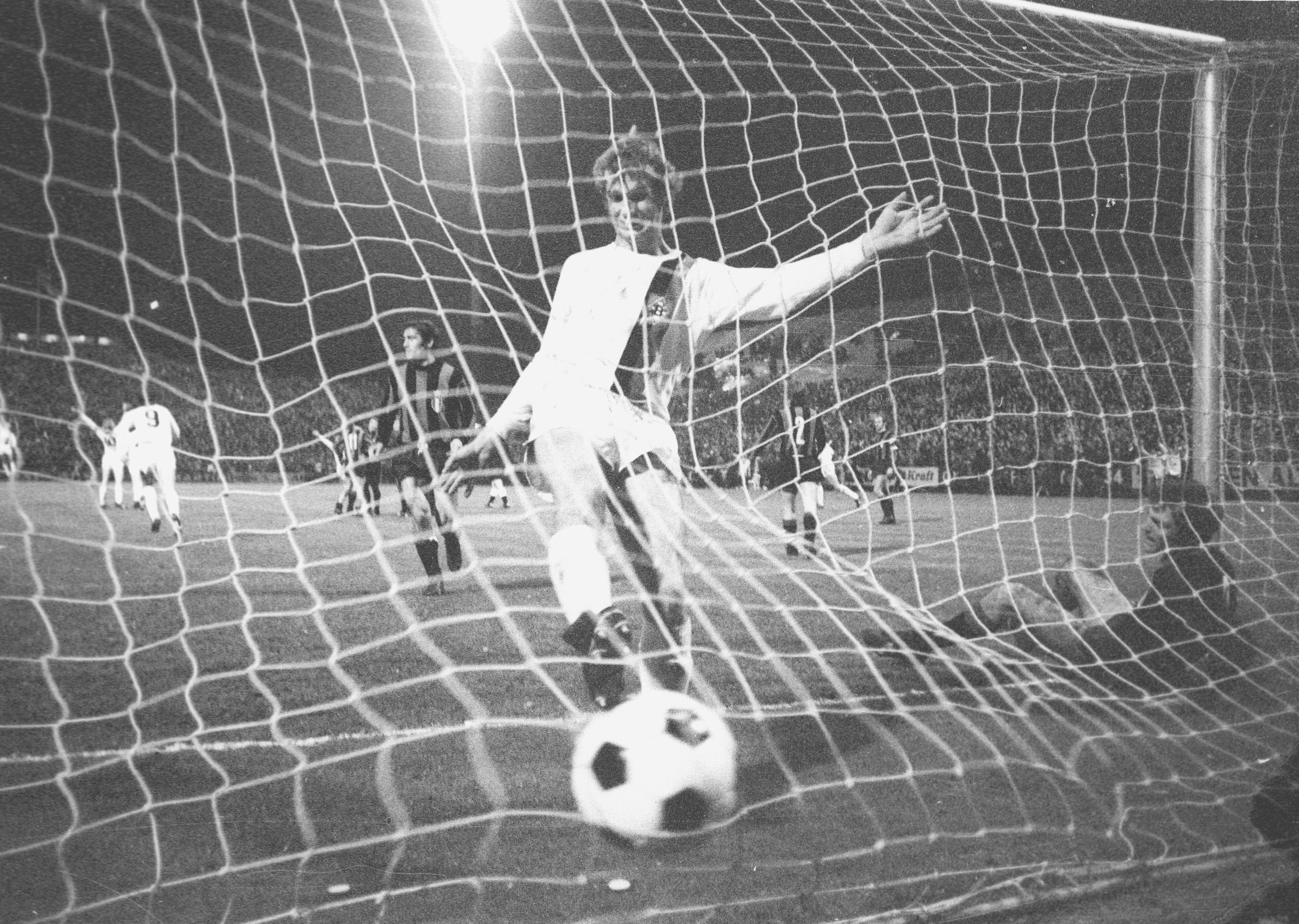 Borussias Rainer Bonhof läuft jubelnd mit dem Ball ins Tor.