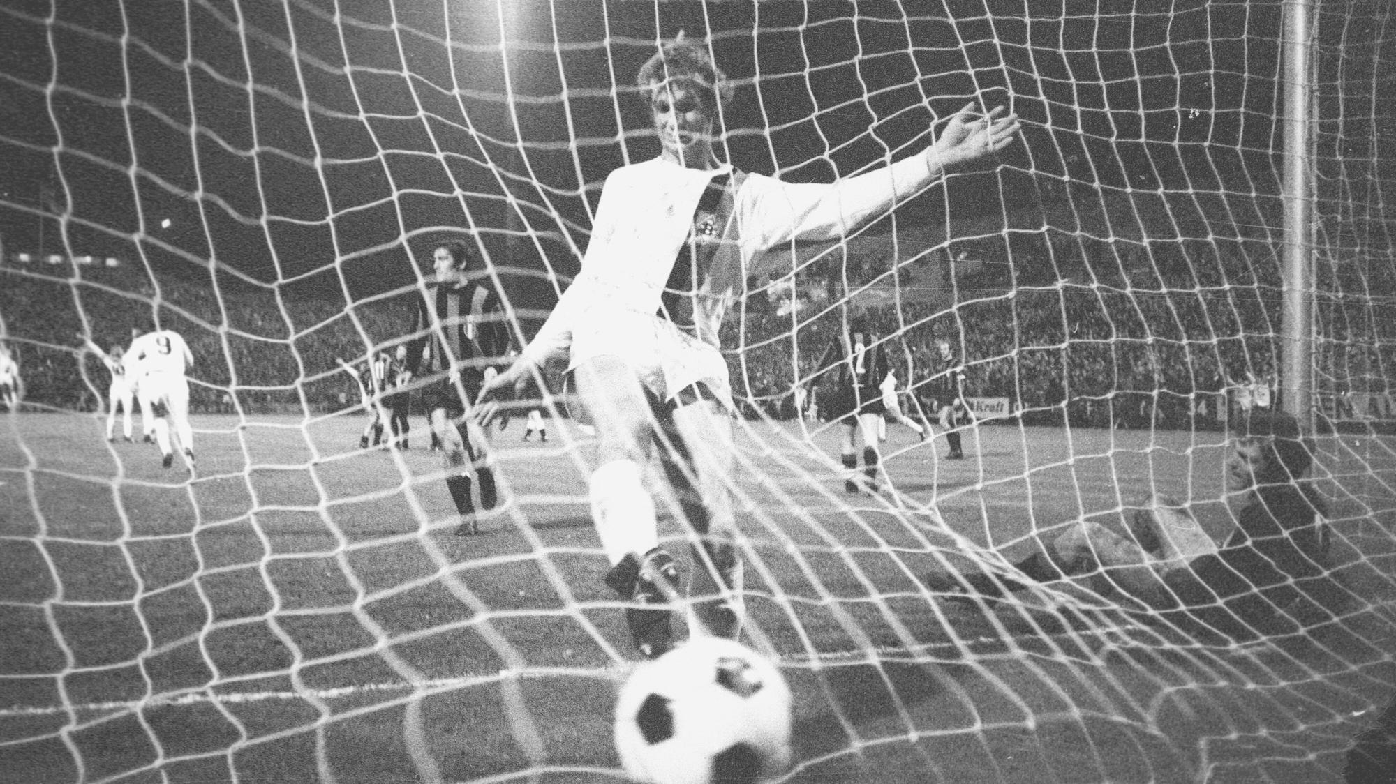Borussias Rainer Bonhof läuft jubelnd mit dem Ball ins Tor.