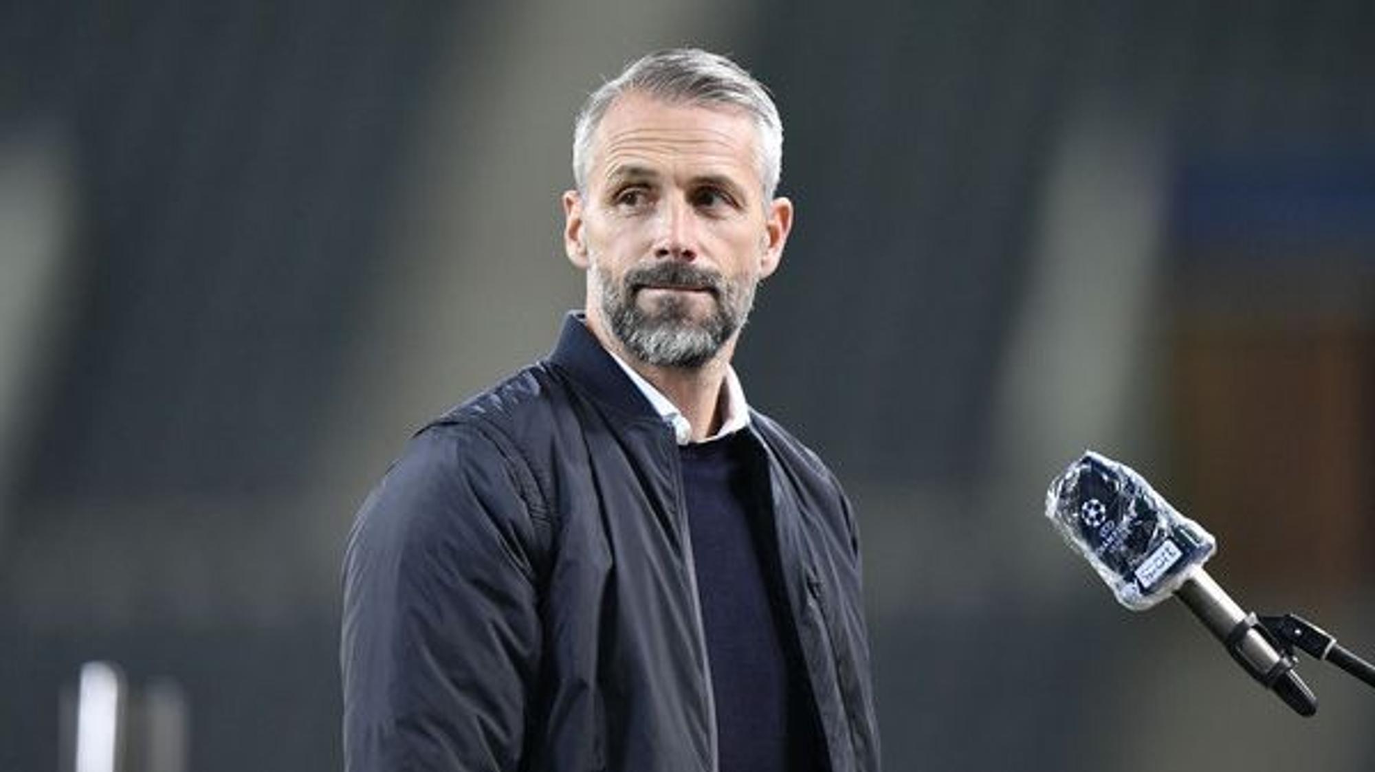 Marco Rose, Trainer der Gladbacher Borussia, blickt vor einem Interview noch einmal mit skeptischem Gesichtsausdruck in die Kamera eines Fotografen.