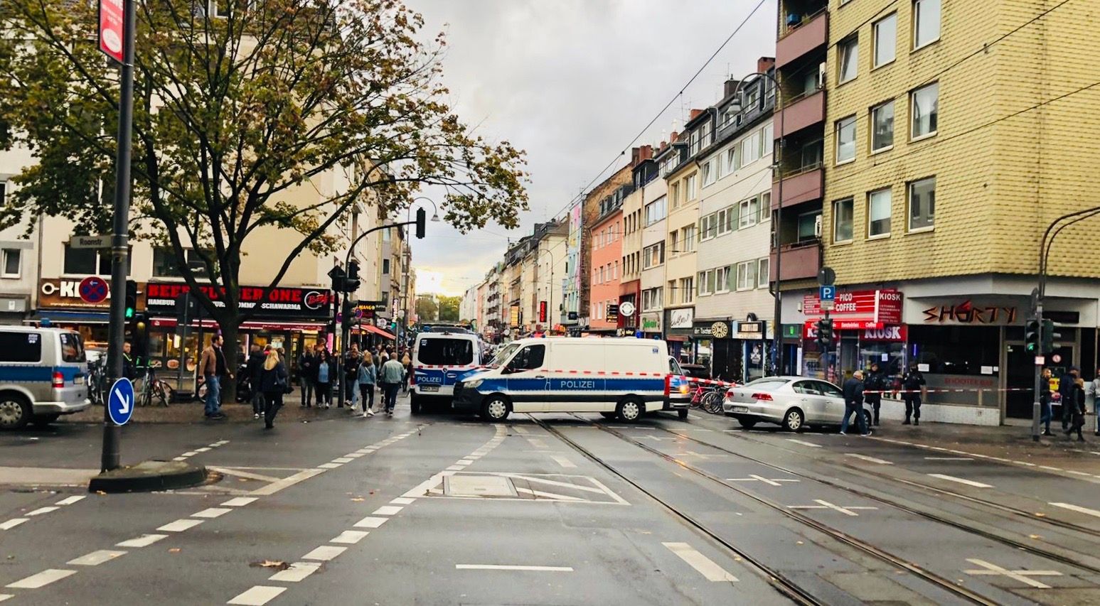 Mehrere Polizeiautos riegeln in der Stadt Köln eine Straße ab.