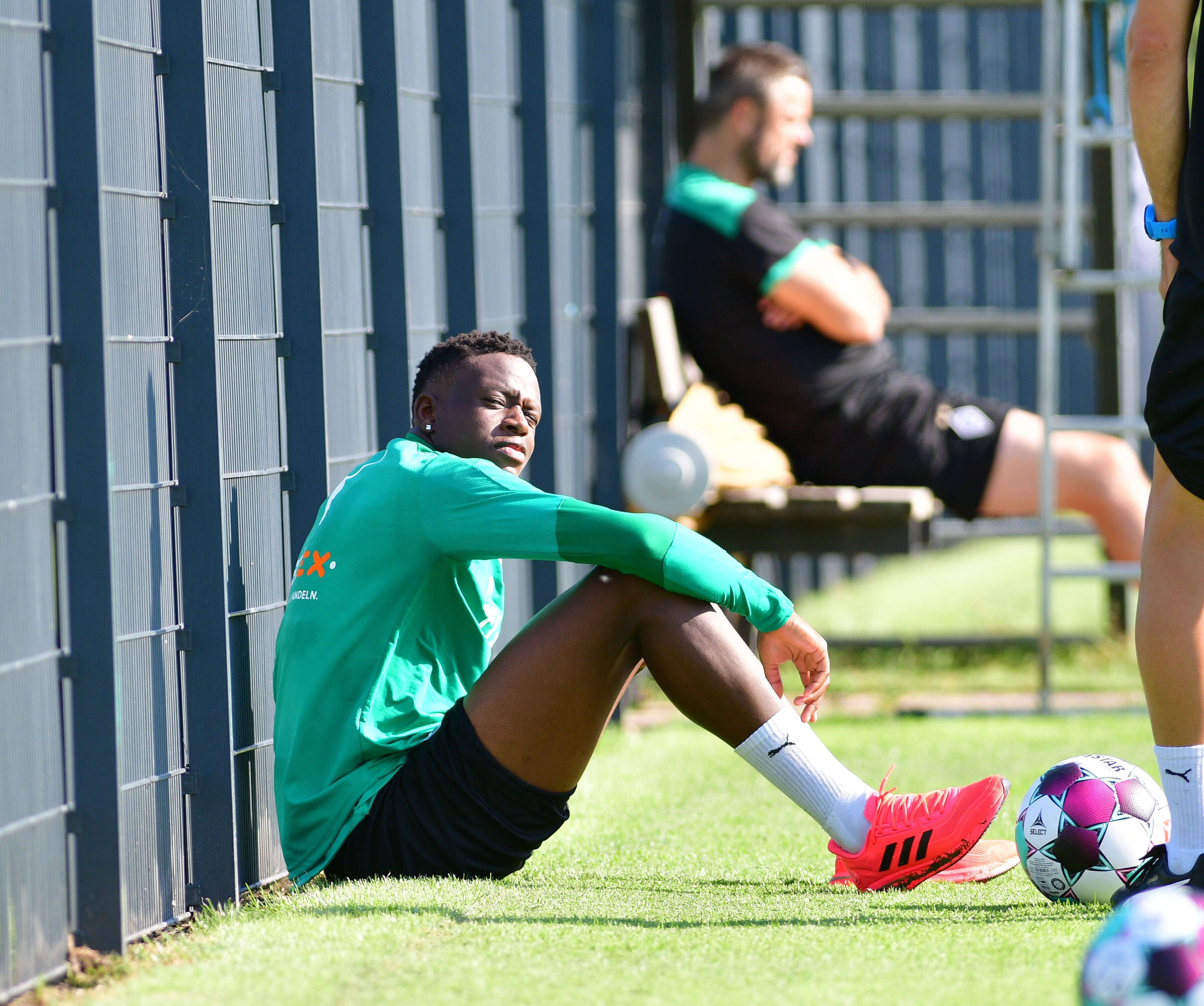 Denis Zakaria von Borussia Mönchengladbach, blickt, geblendet durch die Sonne,  in die Kamera eines Fotografen.