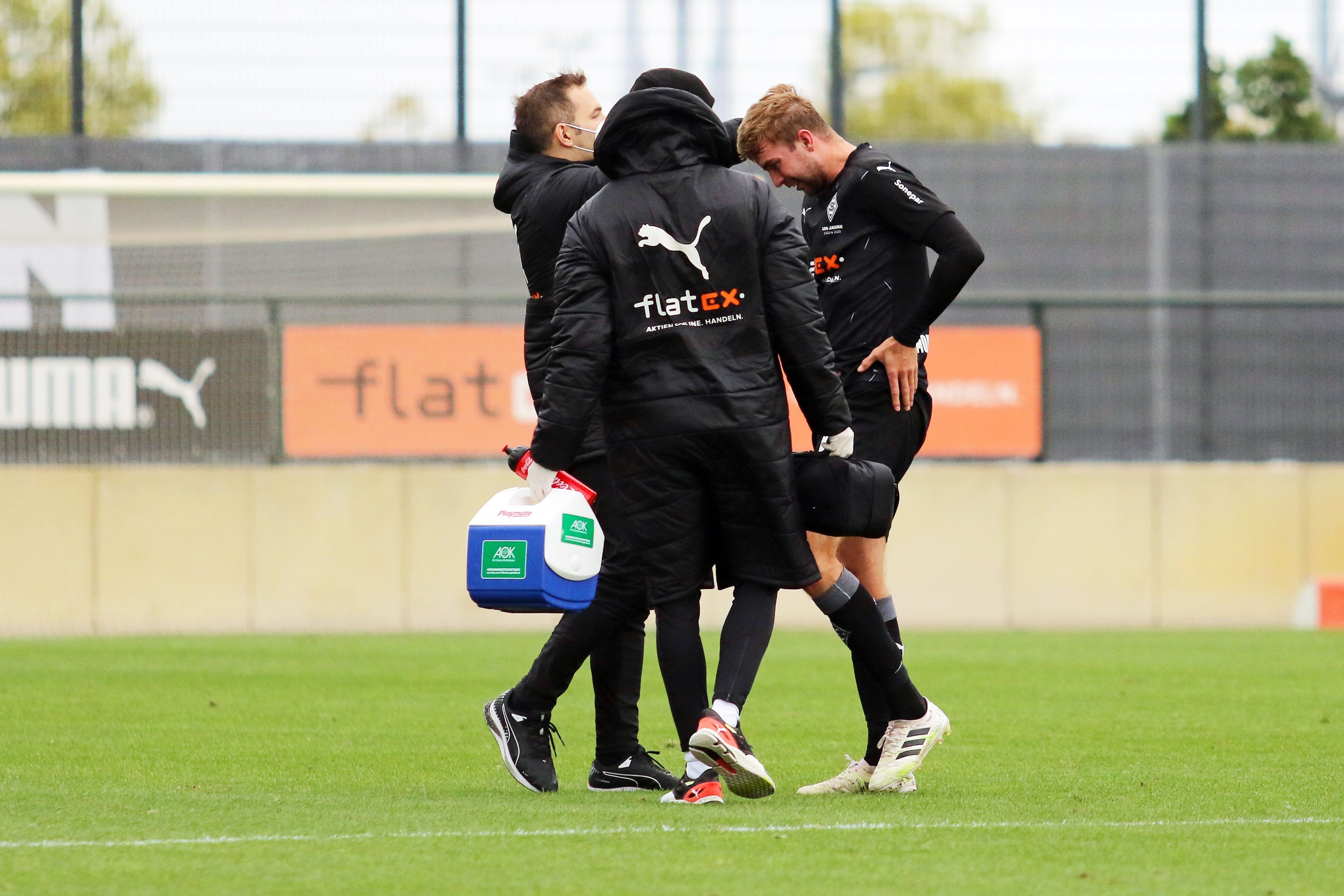 Christoph Kramer, Mittelfeldspieler der Gladbacher Borussia, wird von zwei Medizinern am Spielfeldrand behandelt.