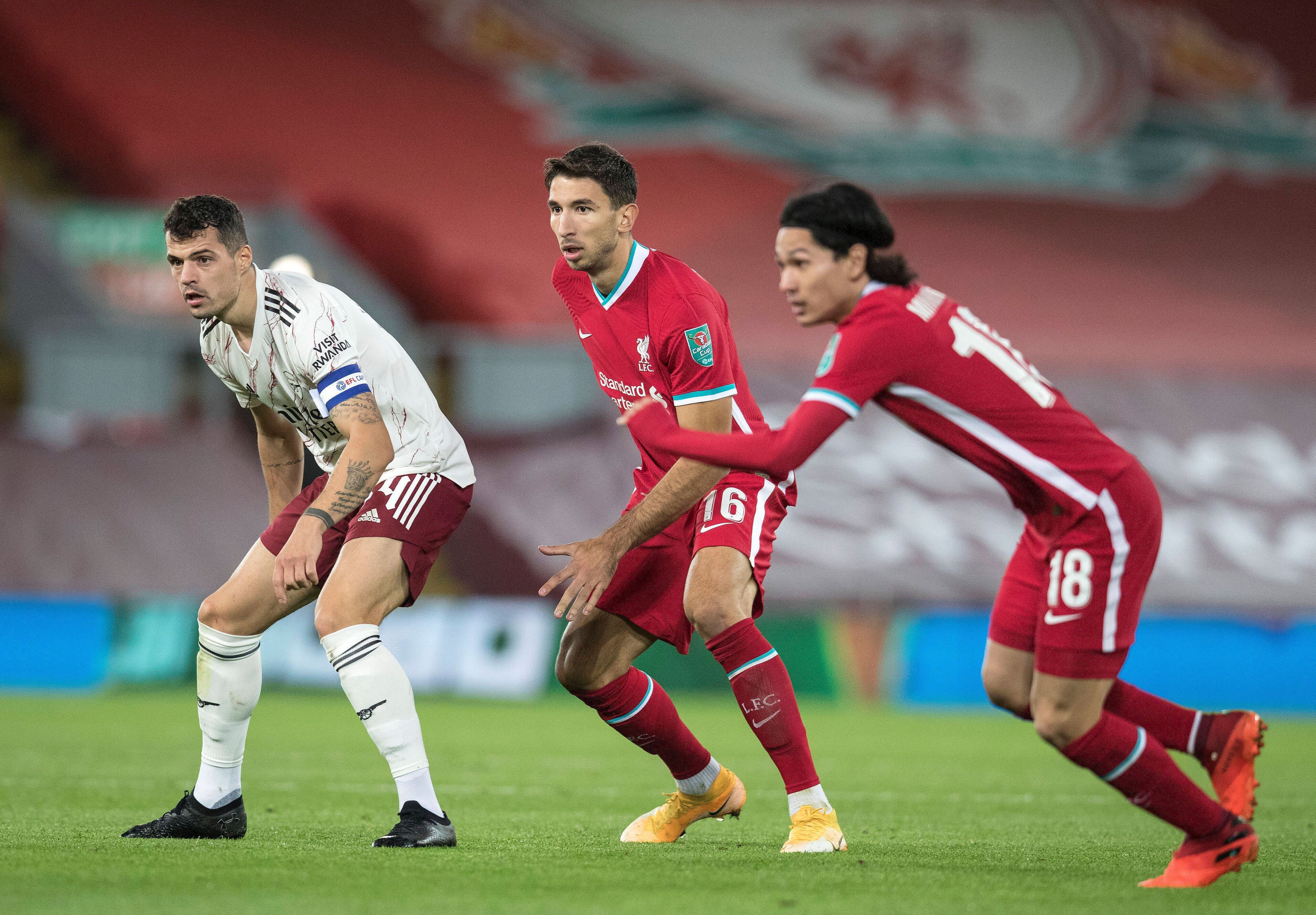 Die Fußballprofis Marko Grujic (Mitte) und Granit Xhaka (l.) blicken während eines Spiels gespannt auf den Ball.