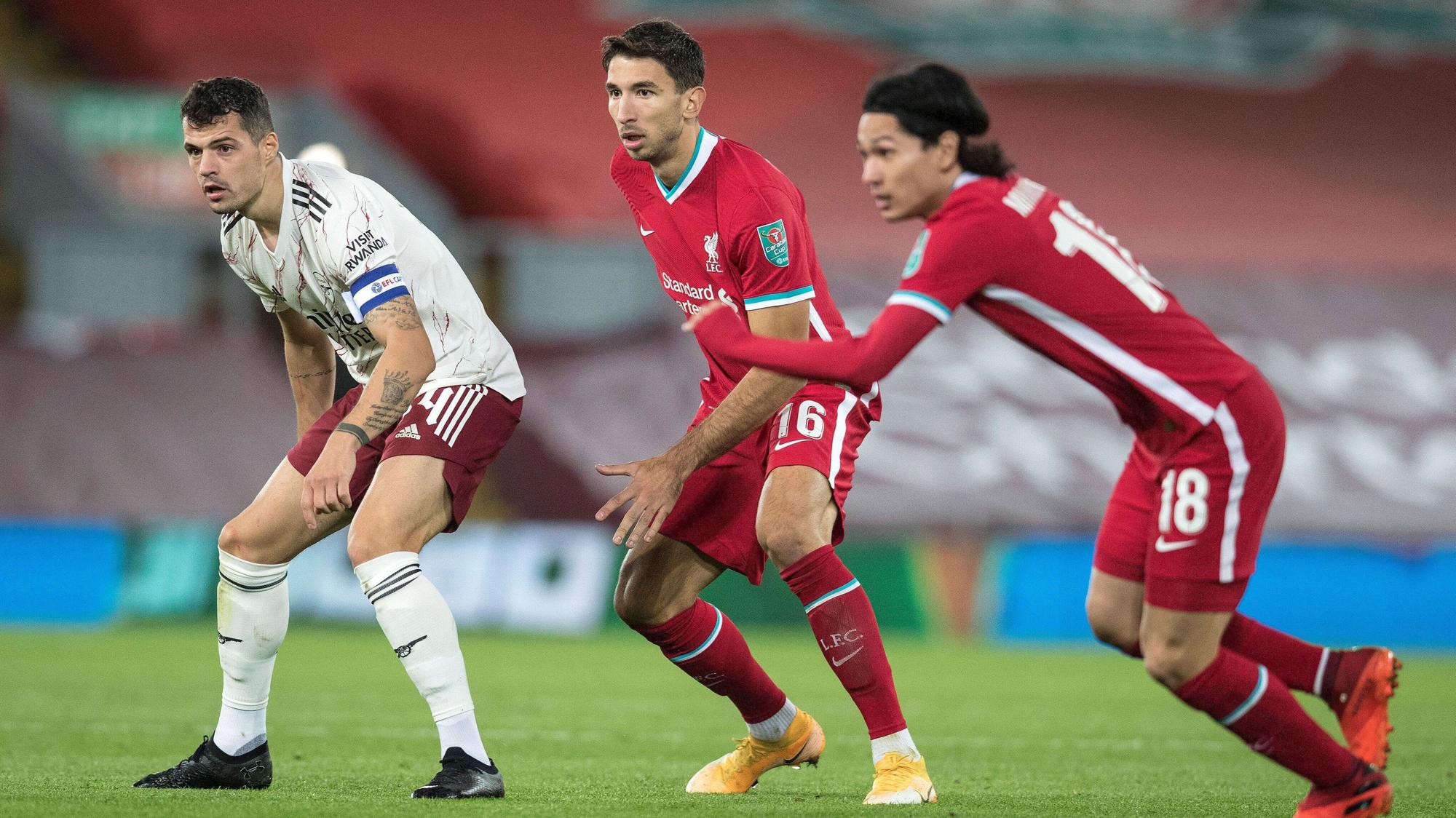 Die Fußballprofis Marko Grujic (Mitte) und Granit Xhaka (l.) blicken während eines Spiels gespannt auf den Ball.