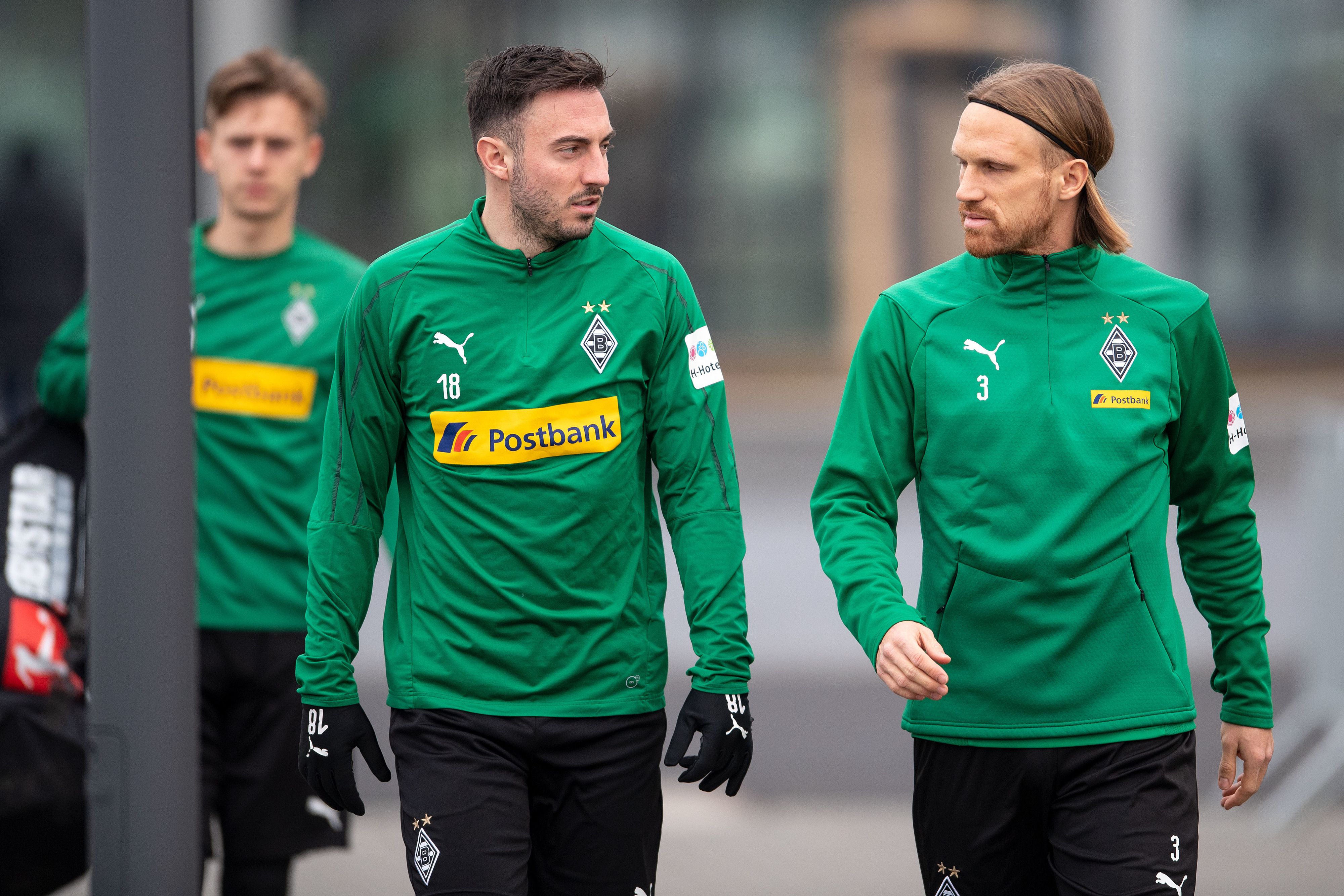 Die Gladbacher Josip Drmic (m.) und Michael Lang betreten Januar 2019 das Trainingsgelände.