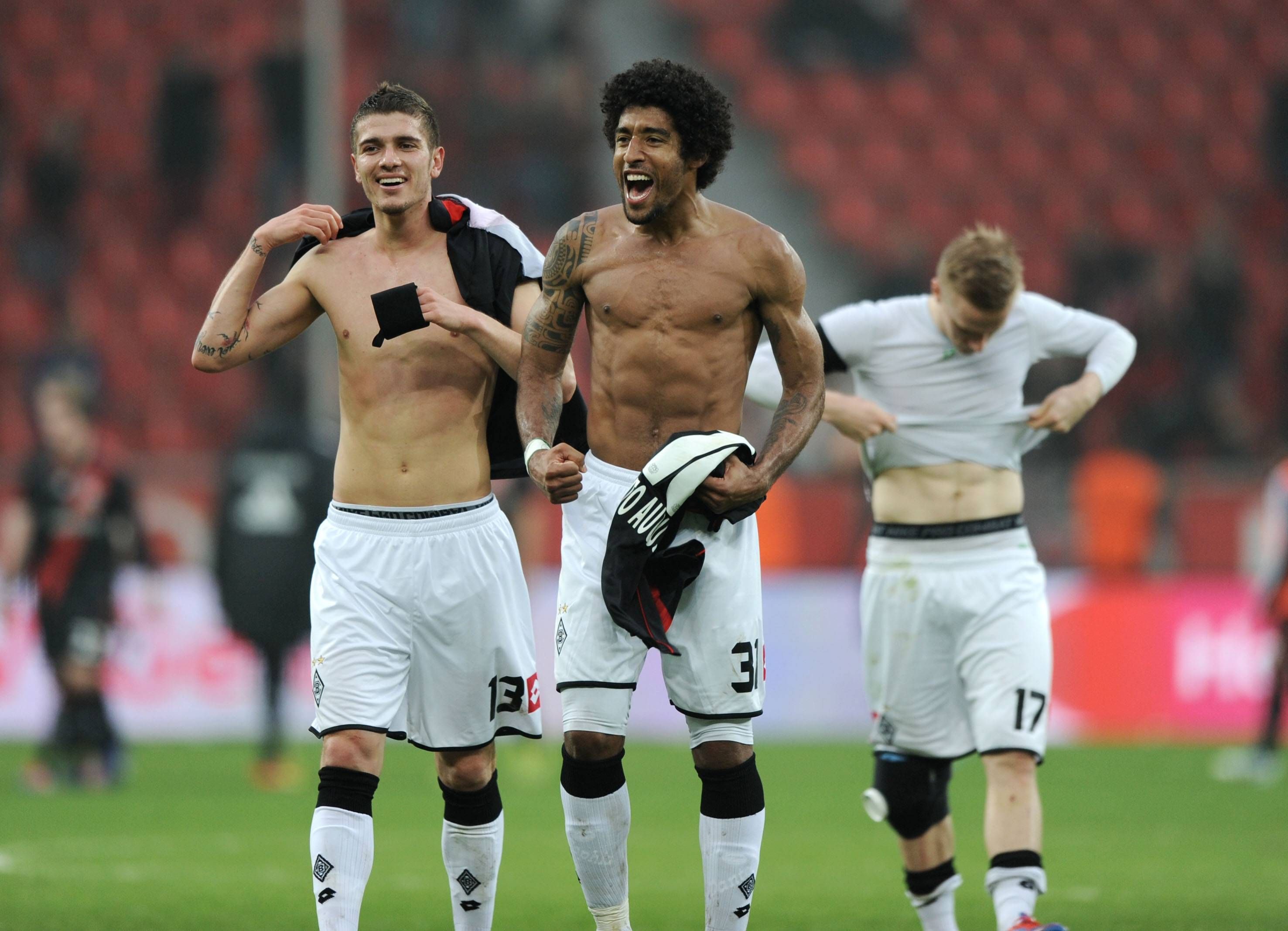 Der brasilianische Abwehrstar Dante (M.), hier gemeinsam mit Roman Neustädter (l.), im Hintergrund Oscar Wendt, zeigt im März 2012 seinen nackten Oberkörper.