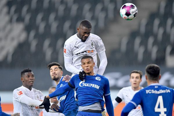 Marcus Thuram (oben), Stürmer der Gladbacher Borussia, setzt sich gegen Schalkes Malick Thiaw (M.) durch