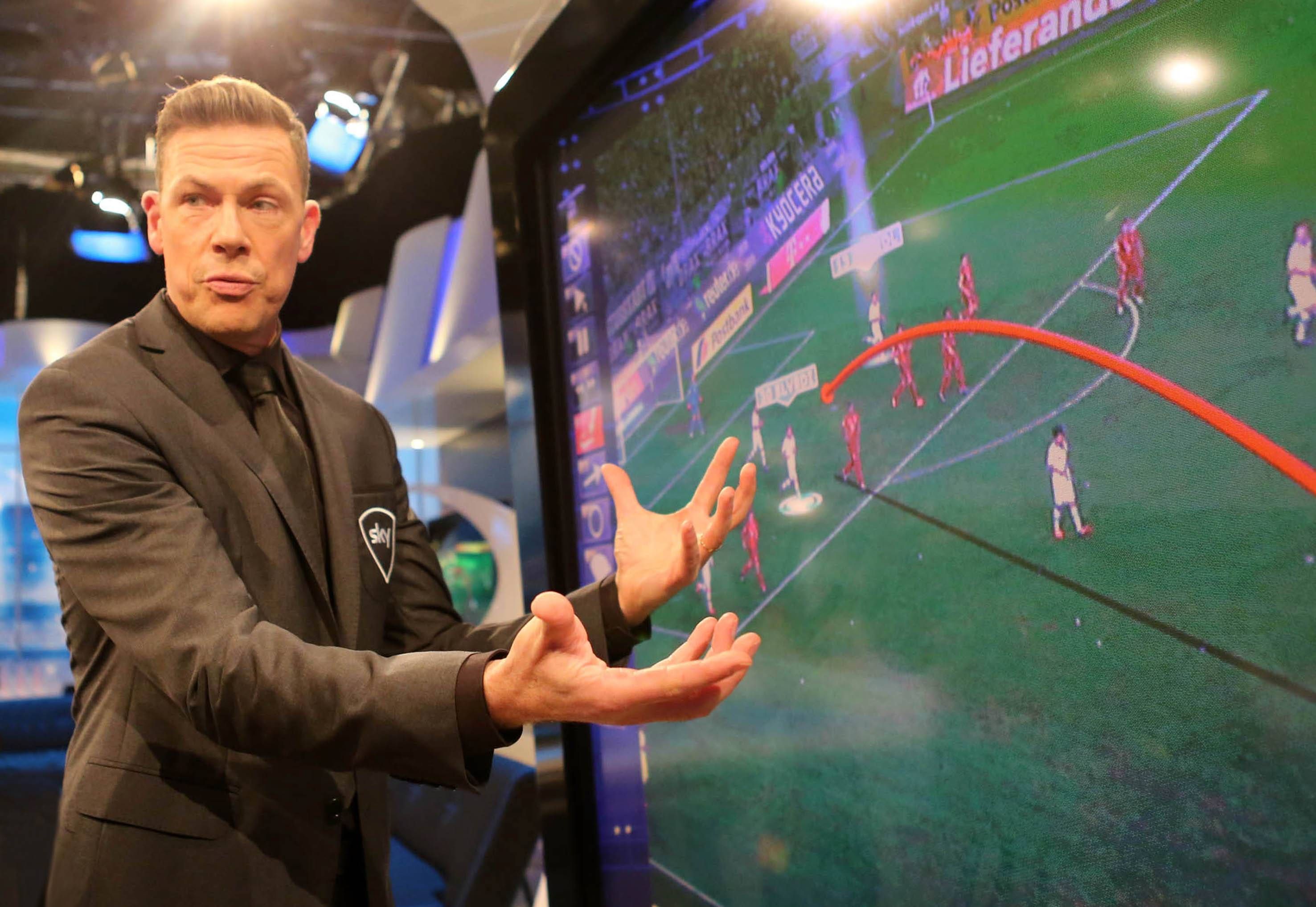 Erik Meijer analysiert vor einer Videowand eine Spielszene als Experte für den TV-Sender Sky.