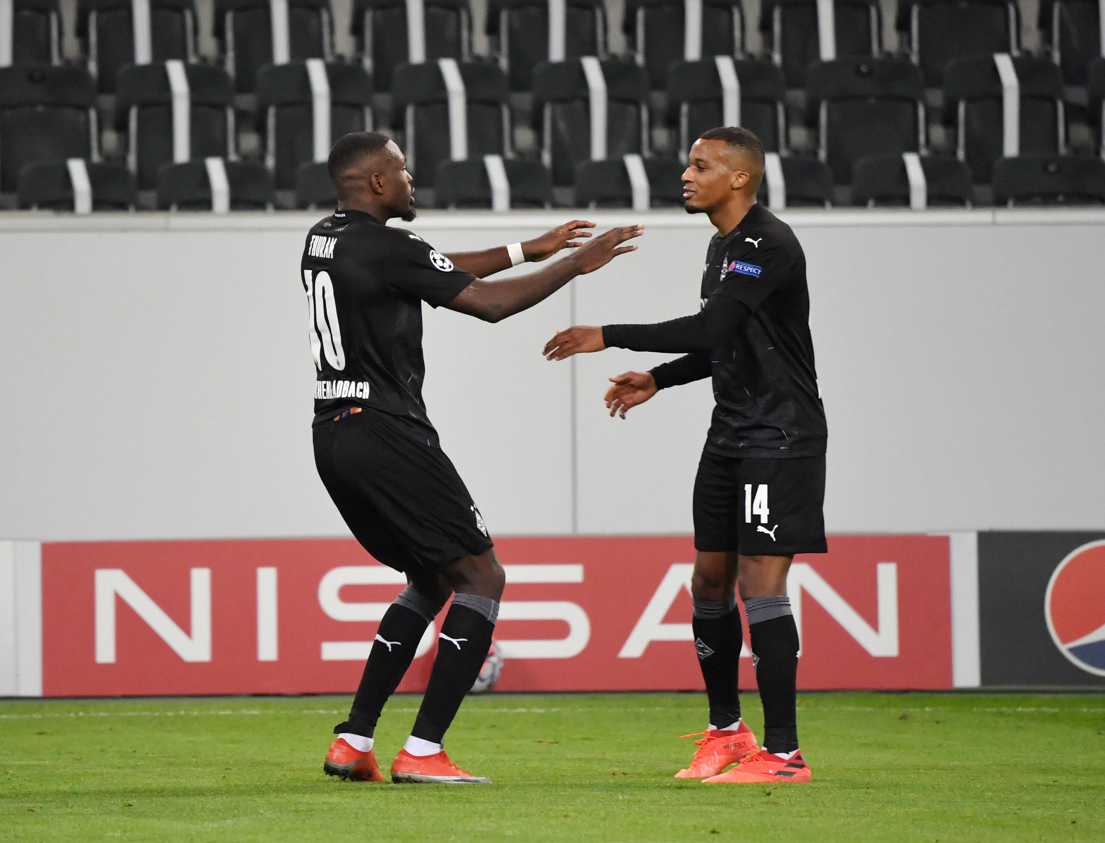 Borussias französische Torjäger Marcus Thuram (l.) und Alassane Plea (r.) feiern ein Tor gegen Real Madrid.