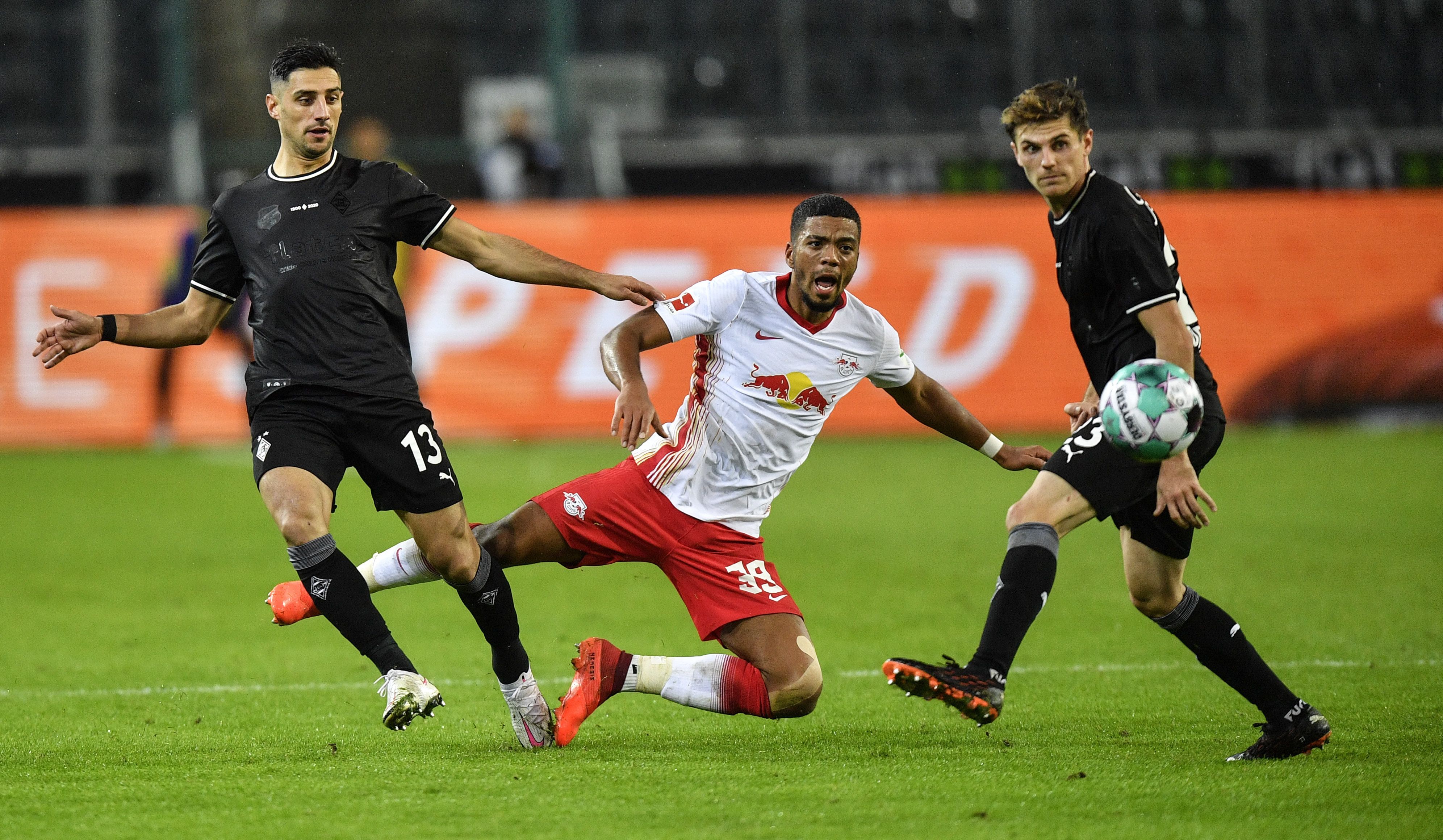 Die Gladbacher Lars Stindl (l.) und Jonas Hofmann (r.) stoppen Leipzigs Benjamin Henrichs (m.)