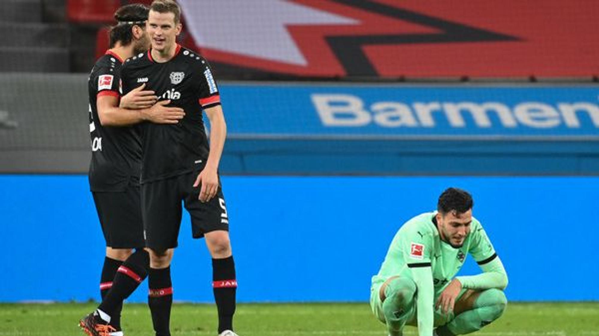 Freude bei den Leverkusenern Aleksandar Dragovic (l.) und Sven Bender (M.), Enttäuschung bei Gladbachs Ramy Bensebaini (r.).