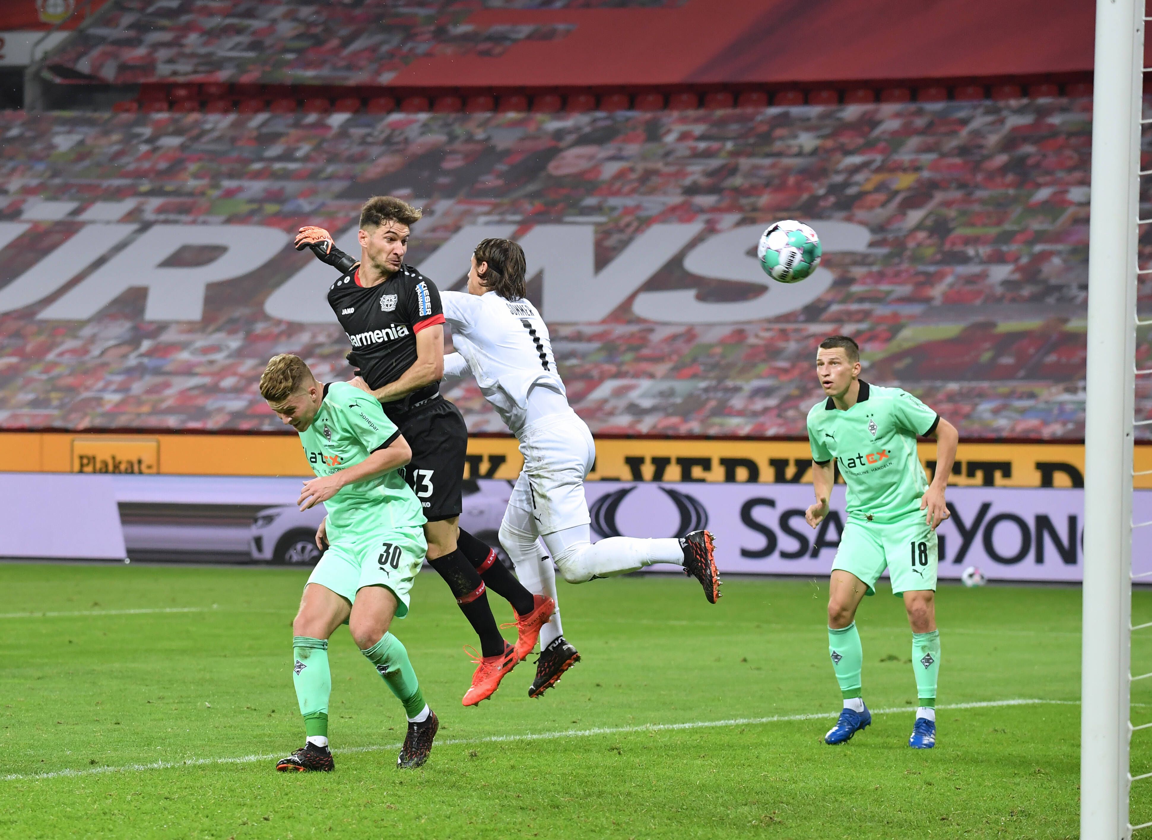 Lucas Alario (M.) köpft für Bayer Leverkusen zum 2:2 gegen Mönchengladbach ein. Borussias Verteidiger Nico Elvedi (l.) und Schlussmann Yann Sommer (r.) können den Angreifer nicht daran hindern.