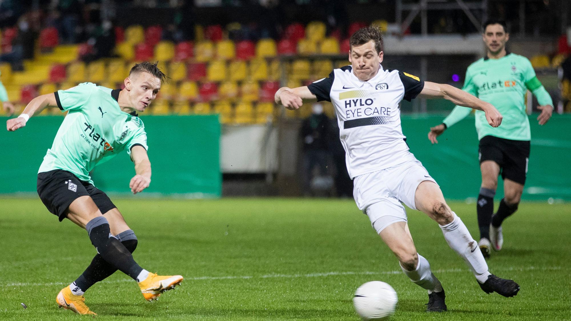 Gladbachs Hannes Wolf (l) macht das Tor zum 0:1 gegen Elversbergs Lukas Kohler (M).