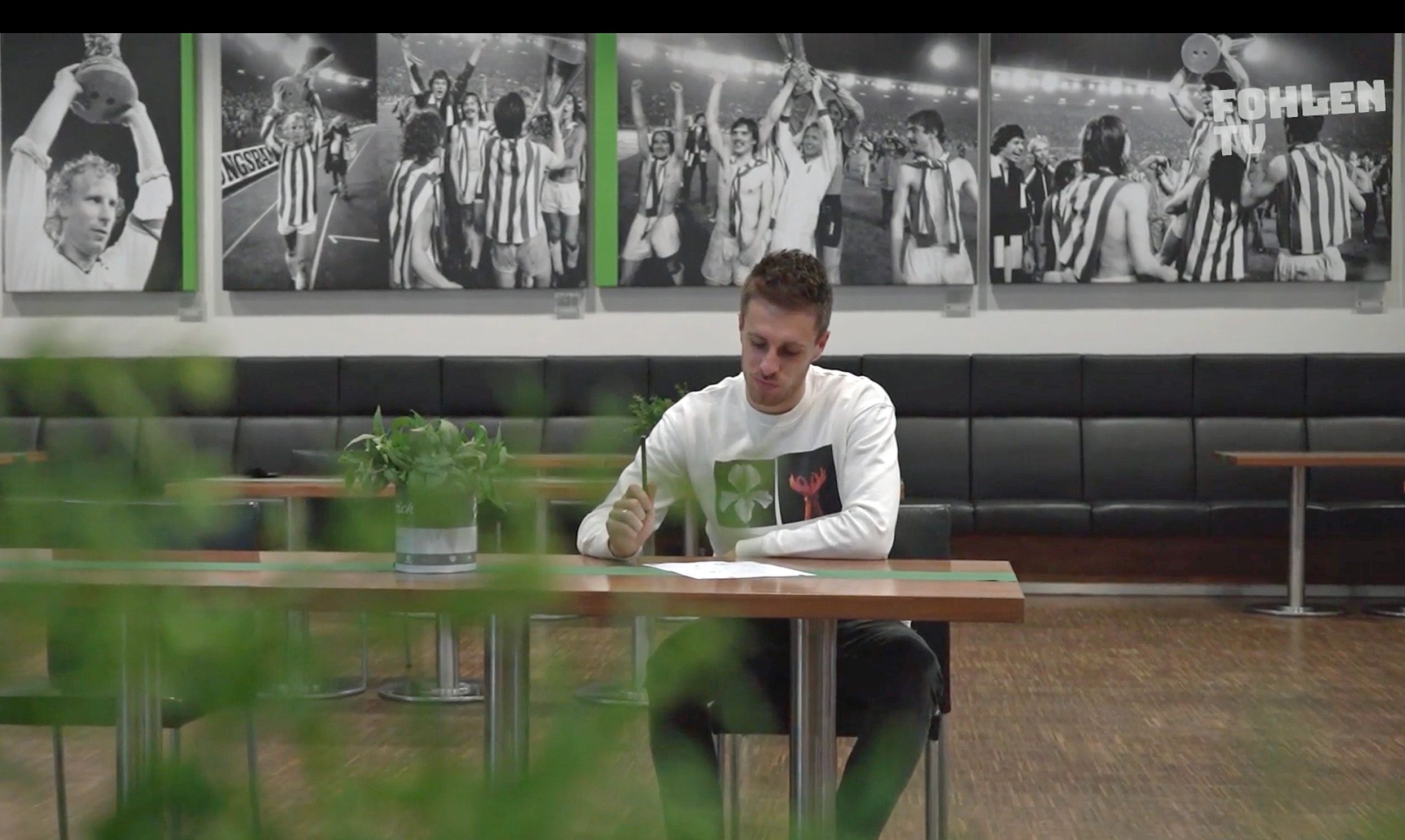 Profispieler Patrick Herrmann sitzt im Business-Bereich des Borussia-Parks und schreibt einen Brief an den Weihnachtsmann.