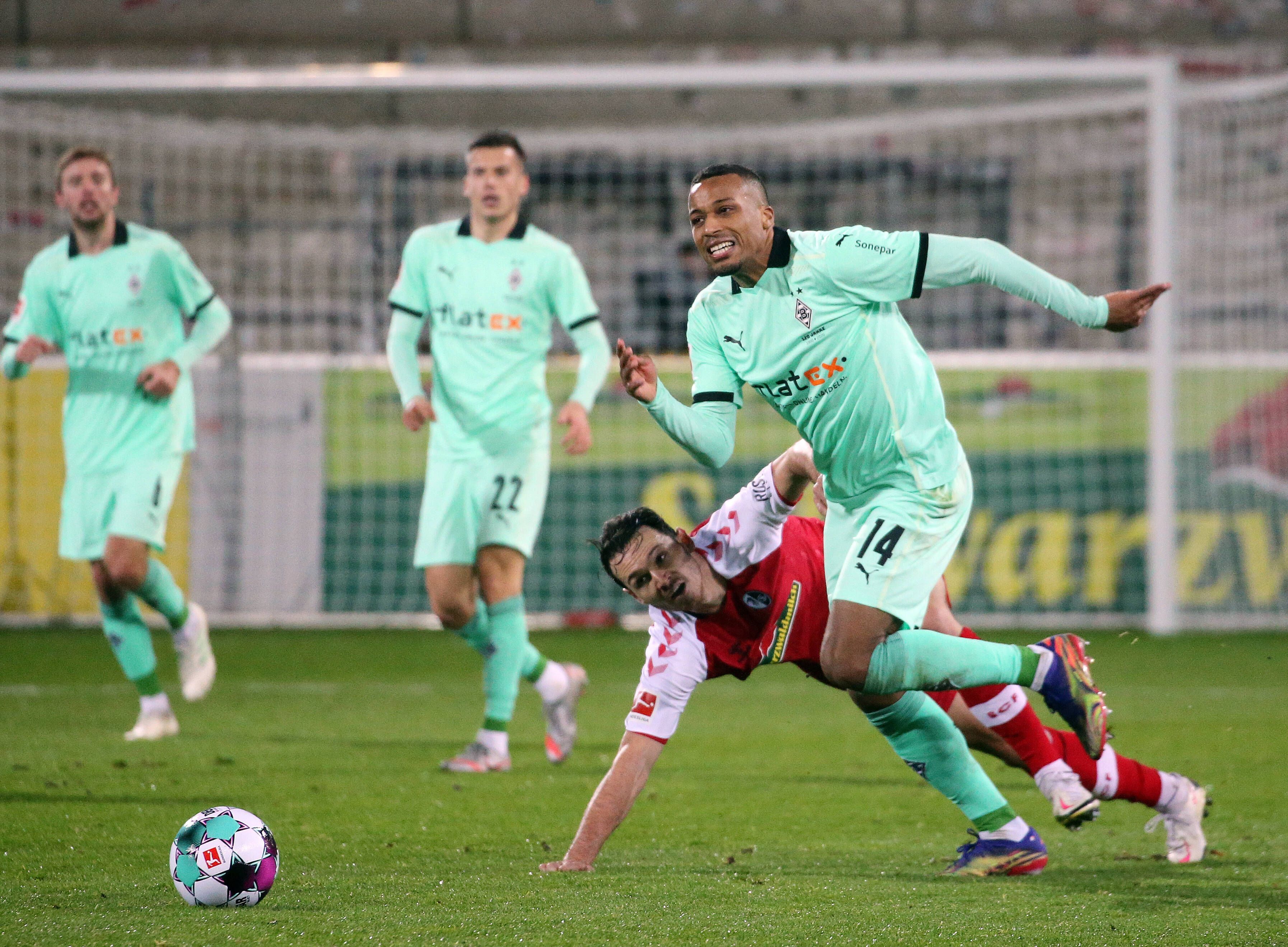 Alassane Plea (r.). hier im Zweikampf mit Freiburgs Nicolas Höfler, beim Bundesliga Spiel der Fohlen beim SC Freiburg am 5. Dezember 2020.