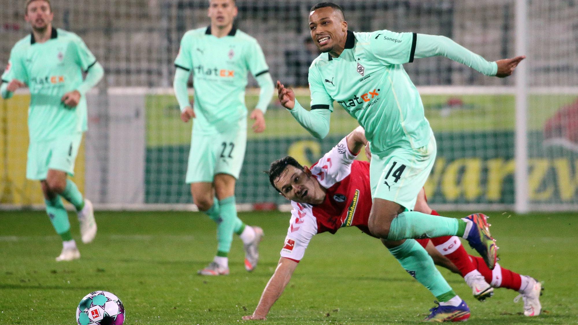 Alassane Plea (r.). hier im Zweikampf mit Freiburgs Nicolas Höfler, beim Bundesliga Spiel der Fohlen beim SC Freiburg am 5. Dezember 2020.