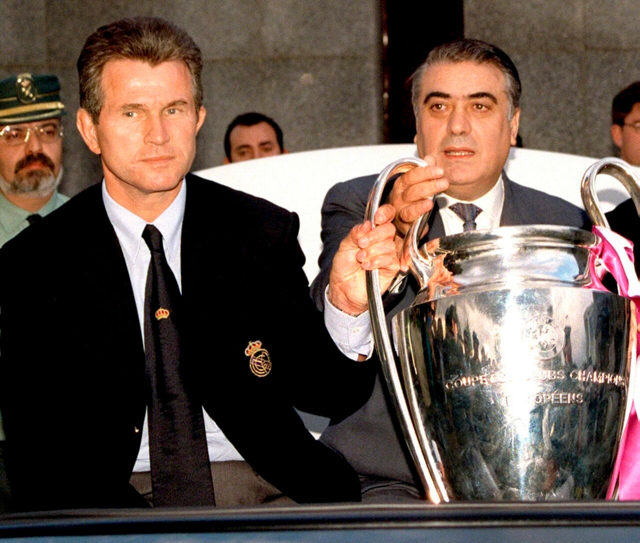 Am 21. Mai 1998 präsentieren Real-Madrid-Präsident Lorenzo Sanz (r.) und Trainer Jupp Heynckes (l.) am Flughafen von Madrid den wartenden Fans den Henkel-Pott, die Trophäe des Siegers der UEFA Champions League.