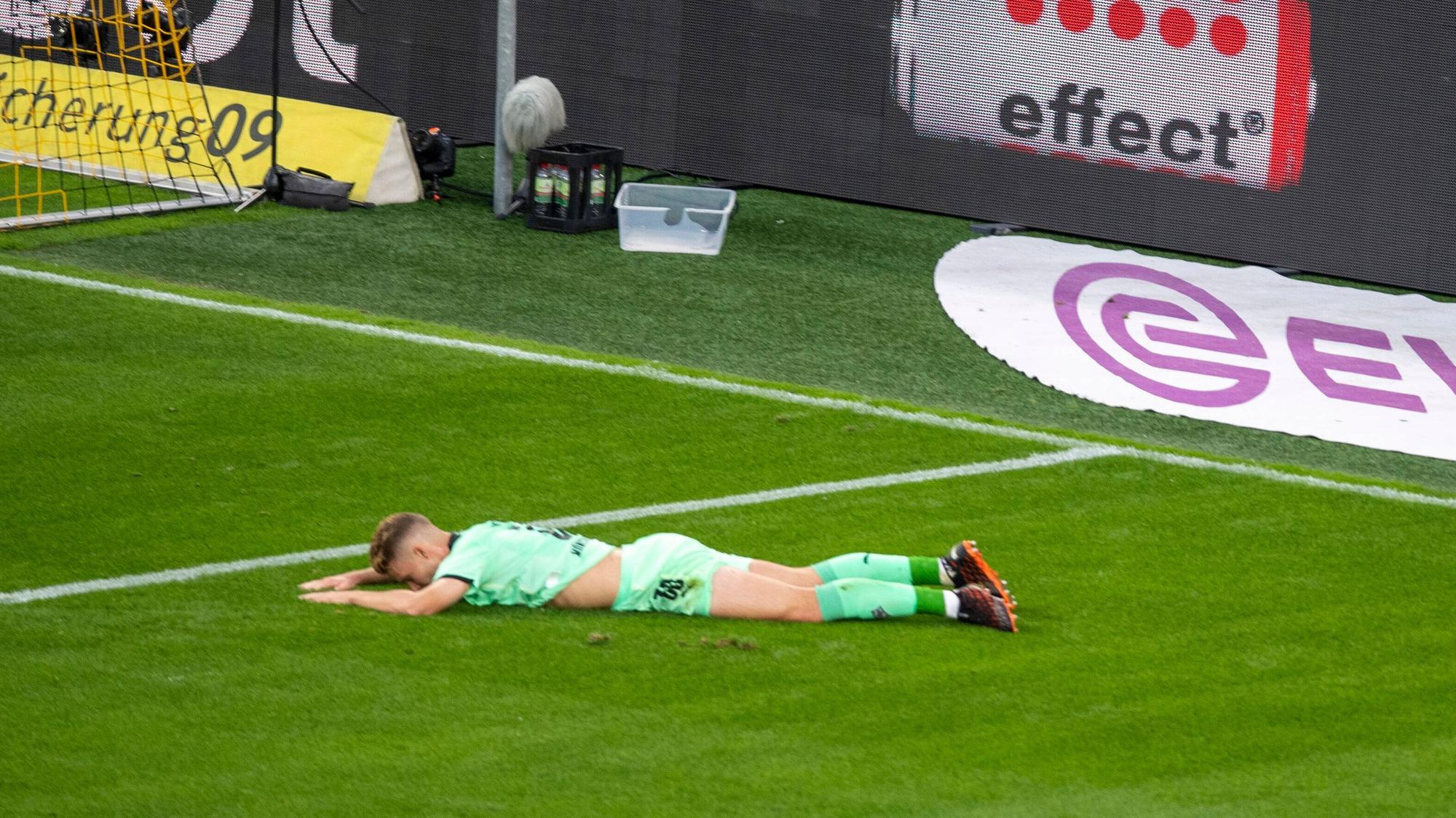 Gladbach-Spieler Nico Elvedi liegt auf dem Rasen im Dortmunder Stadion.