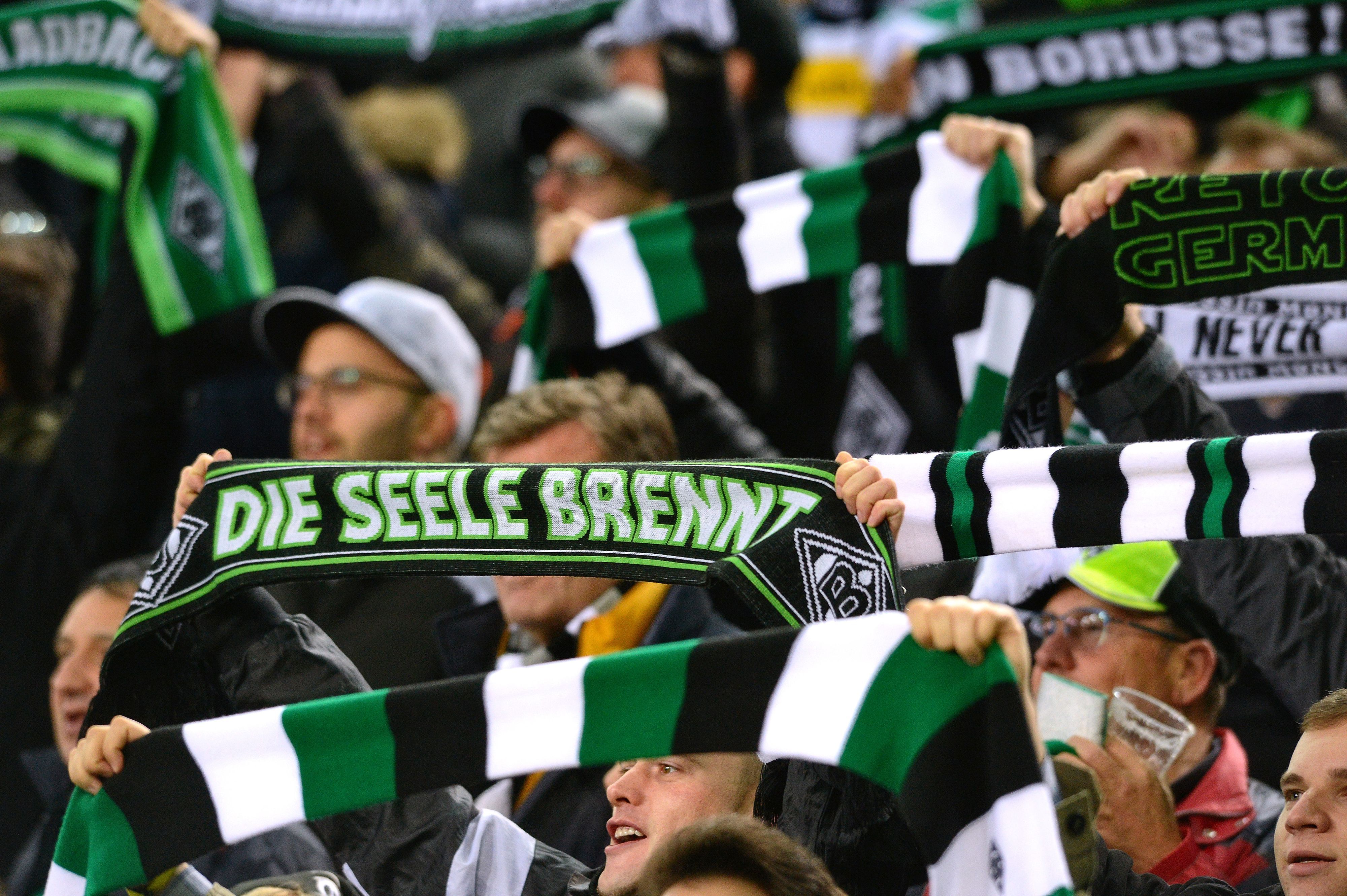 Gladbach-Fans halten ihre Schals hoch.