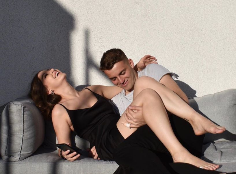 Jordan Beyer und Freundin Julietta Malina posieren auf dem Sofa.