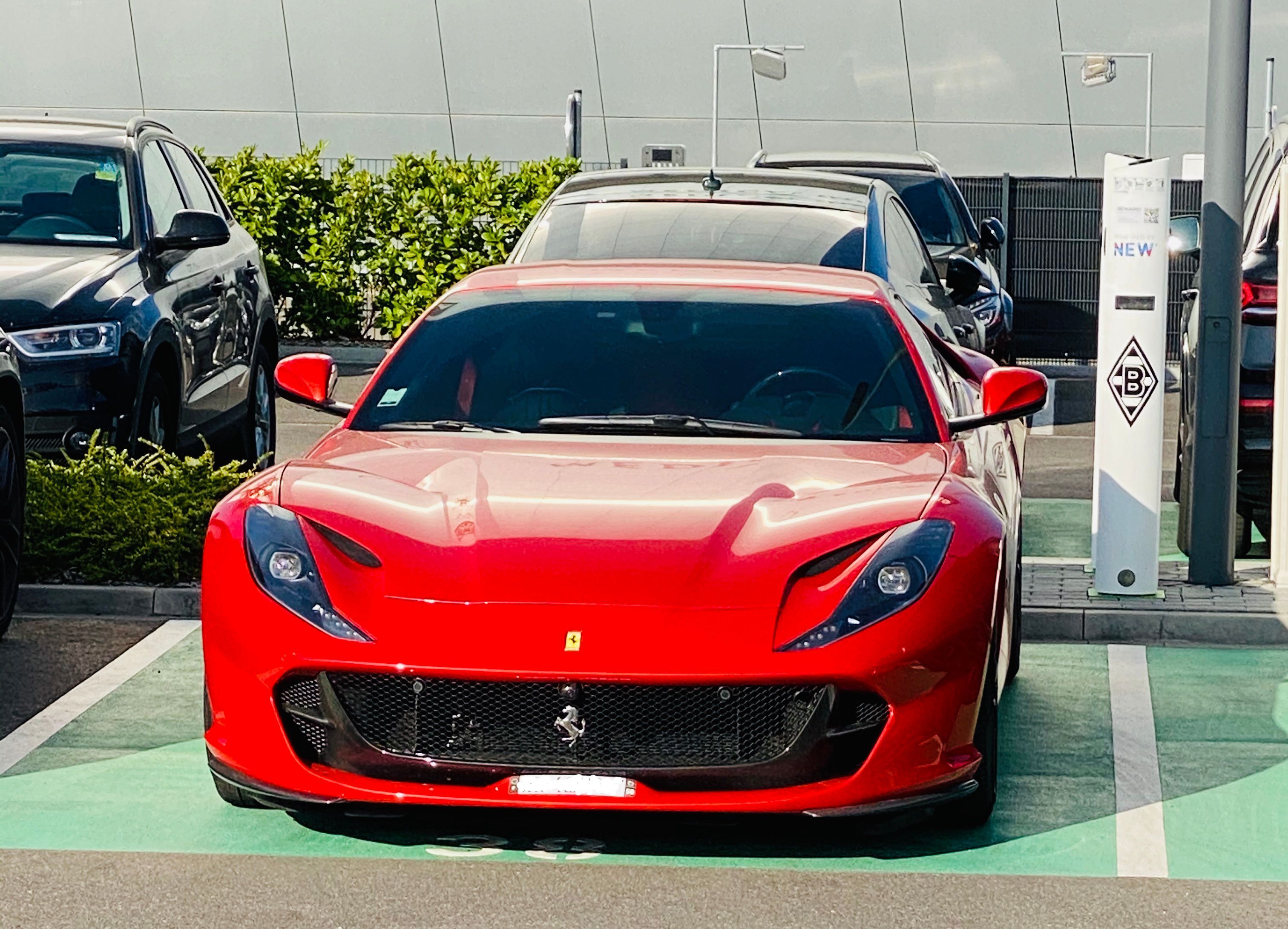 Ein roter Ferrari steht auf einem Parkplatz im Gladbacher Borussia-Park.