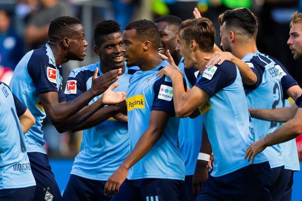 Der Gladbacher Spieler Alassane Plea wird nach einem Torerfolg von seinen Mitspielern umringt.