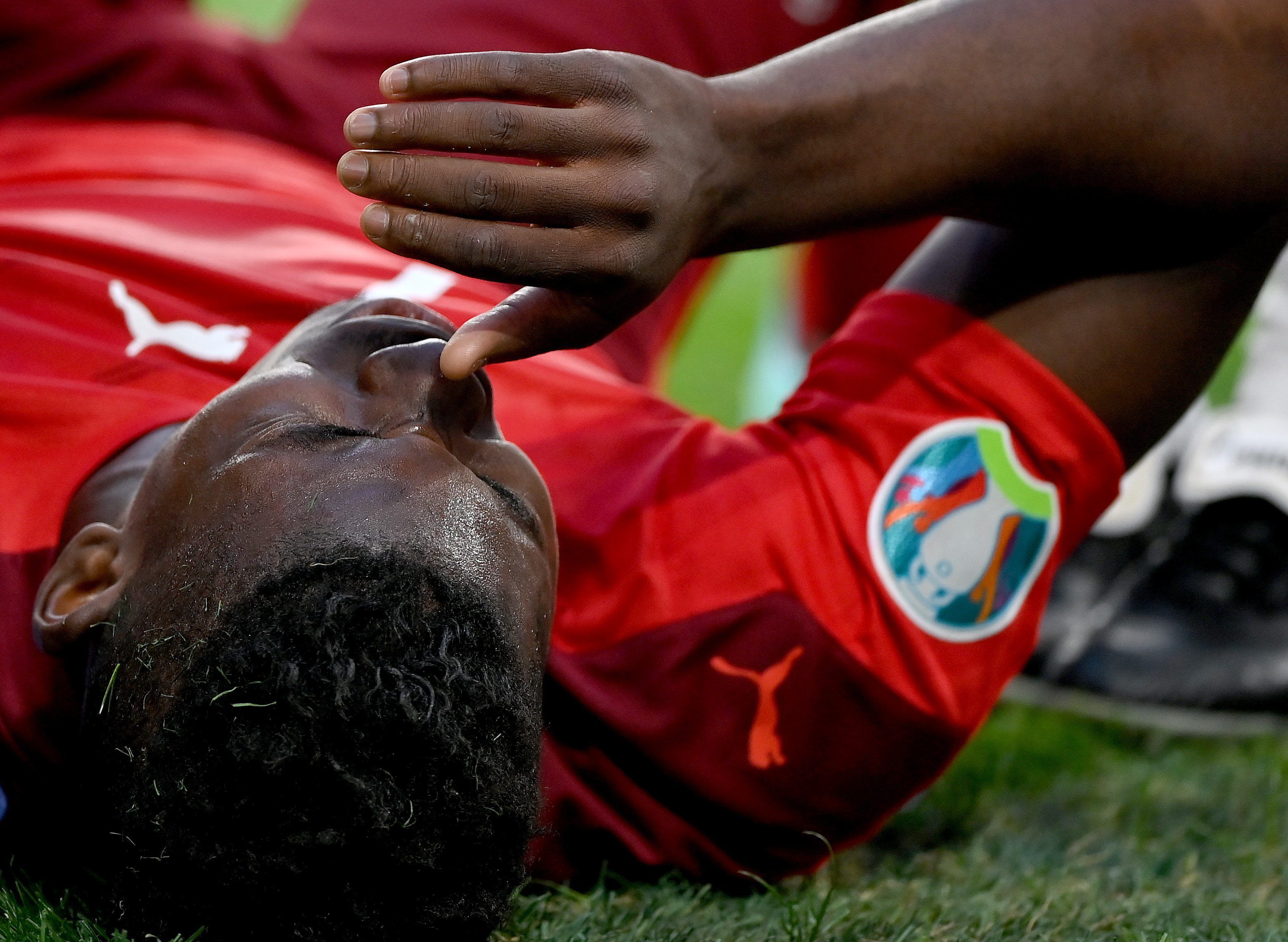 Gladbachs Breel Embolo zog sich im EM-Viertelfinale der Schweiz gegen Spanien am 2. Juli 2021 in St. Petersburg eine Oberschenkelverletzung zu und fällt nun bis auf Weiteres aus. Das Foto zeigt den Schweizer mit Schmerz verzerrtem Gesicht leidend auf dem Boden liegend.