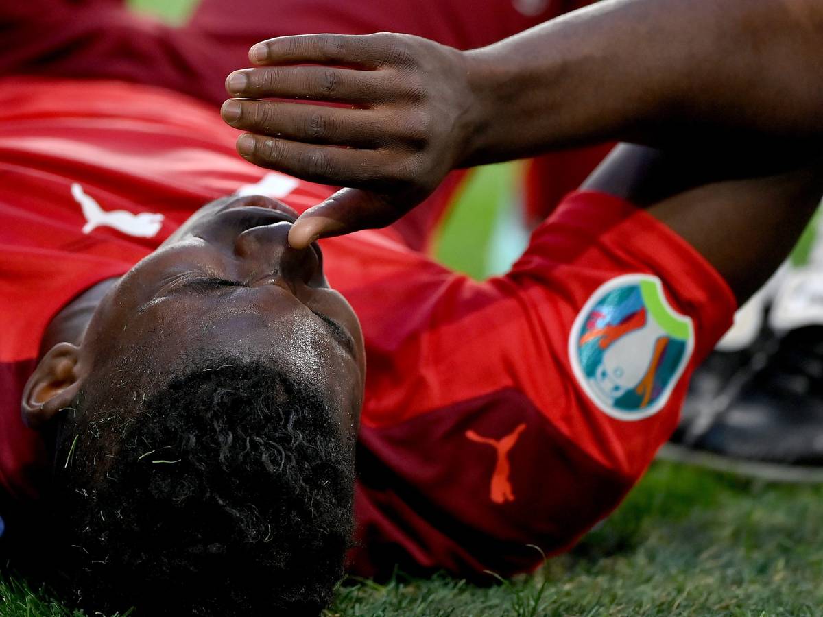 Gladbachs Breel Embolo zog sich im EM-Viertelfinale der Schweiz gegen Spanien am 2. Juli 2021 in St. Petersburg eine Oberschenkelverletzung zu und fällt nun bis auf Weiteres aus. Das Foto zeigt den Schweizer mit Schmerz verzerrtem Gesicht leidend auf dem Boden liegend.