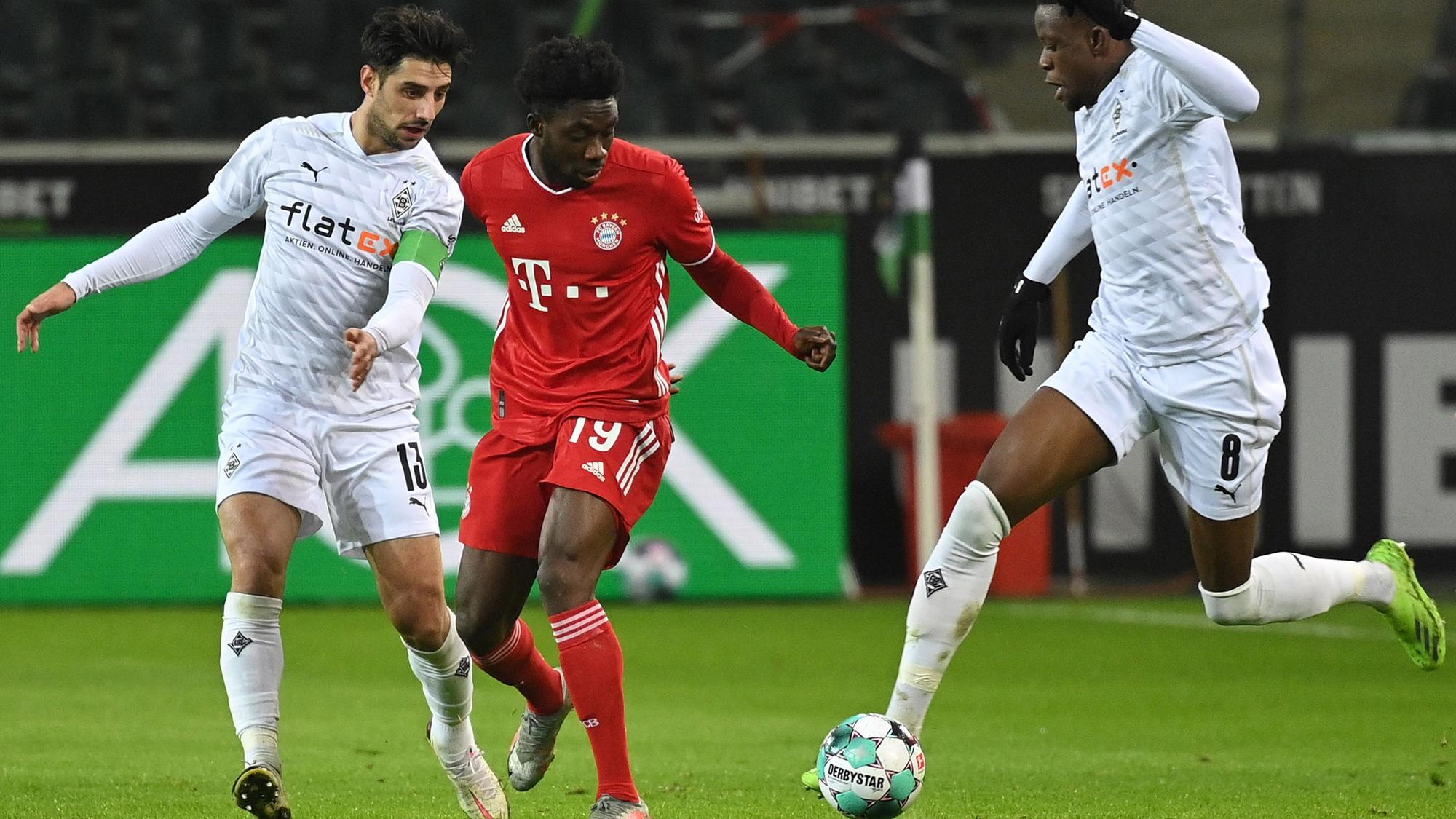Das Foto zeigt Gladbachs Lars Stindl (l.) und Denis Zakaria (r.) im Zweikampf mit Bayerns Alphonso Davies (Mitte) am 8. Januar 2021 im Borussia-Park.
