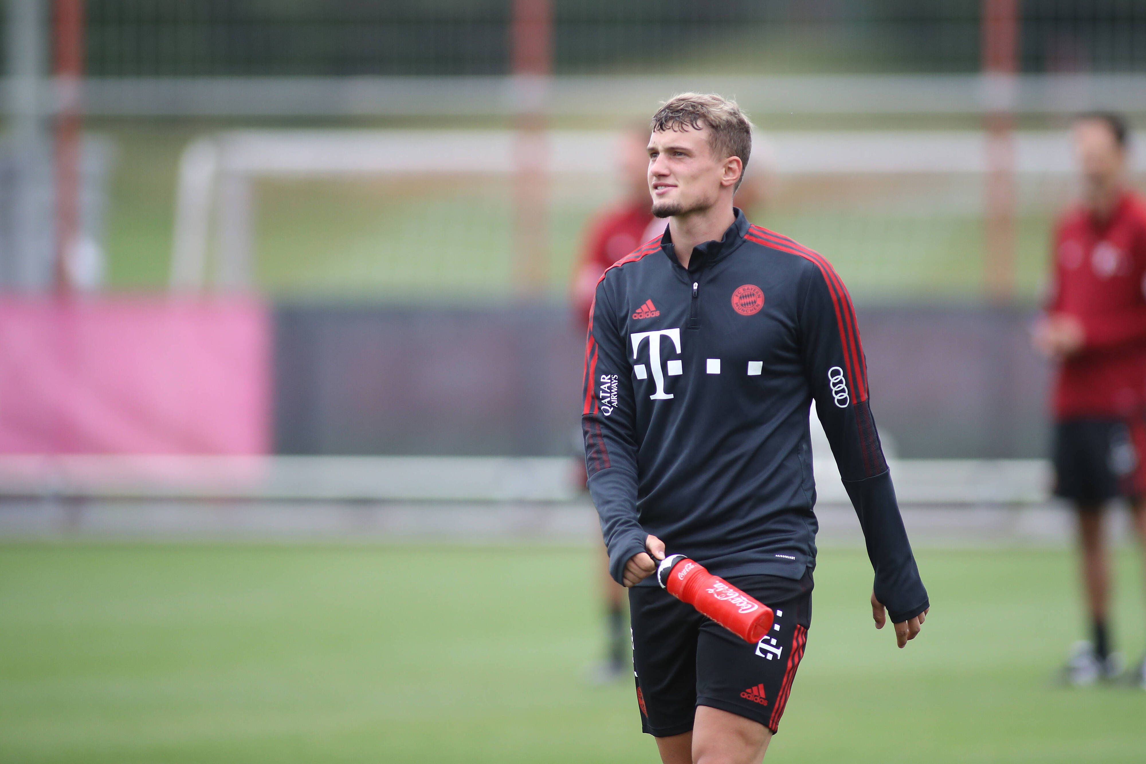 Michael Cuisance beim Training des FC Bayern München, läuft über den Platz und trägt eine rote Trinkflasche mit sich.