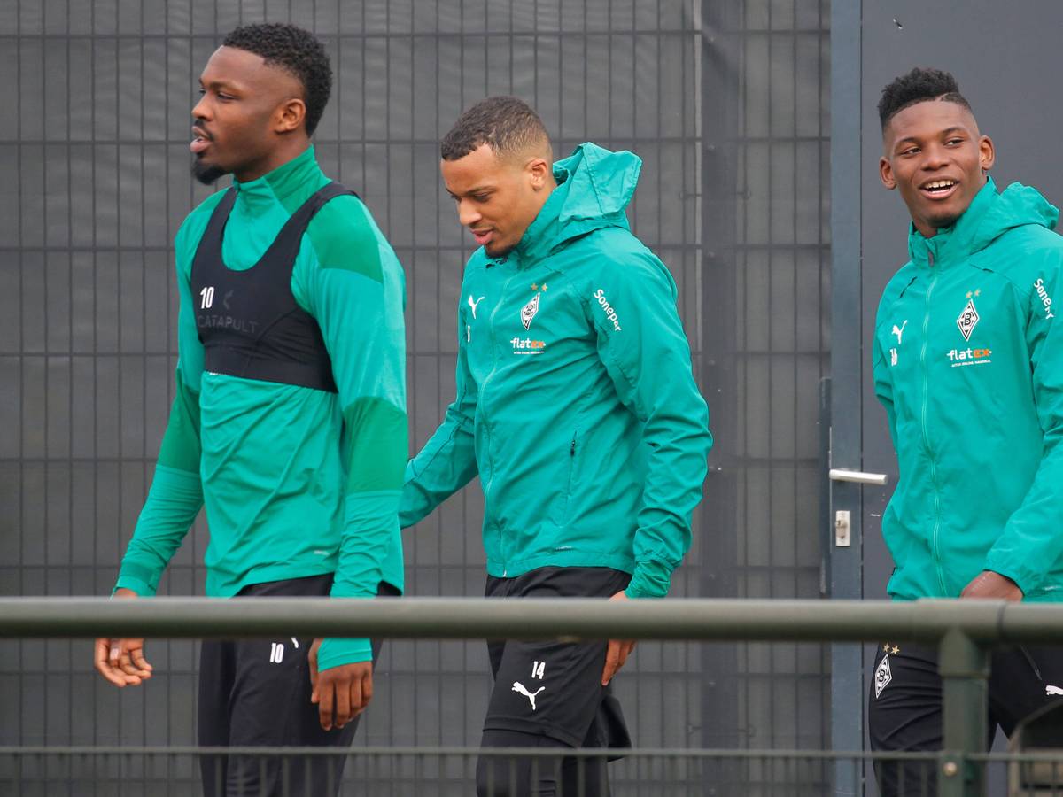 Borussias Stürmer Marcus Thuram (l.), Alassane Plea (Mitte) und Breel Embolo (rechts) am 23. Februar 2021 bei einer Trainingseinheit gut gelaunt im Borussia-Park beim betreten des Platzes.