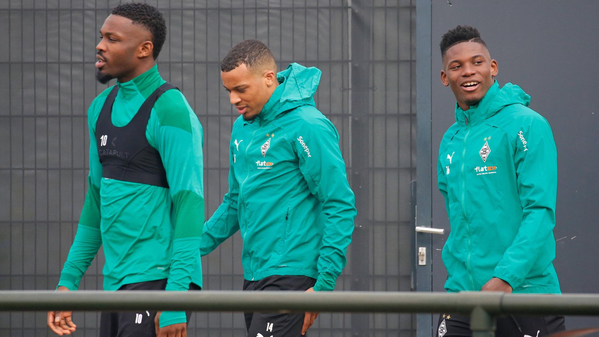 Borussias Stürmer Marcus Thuram (l.), Alassane Plea (Mitte) und Breel Embolo (rechts) am 23. Februar 2021 bei einer Trainingseinheit gut gelaunt im Borussia-Park beim betreten des Platzes.