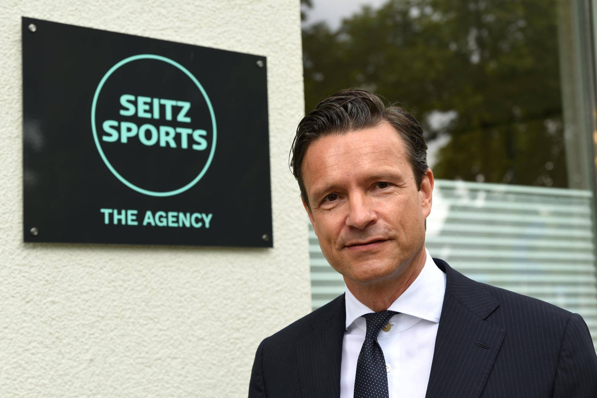 Dr. Stefan Seitz vor dem Logo der neuen Agentur Seitz Sports.