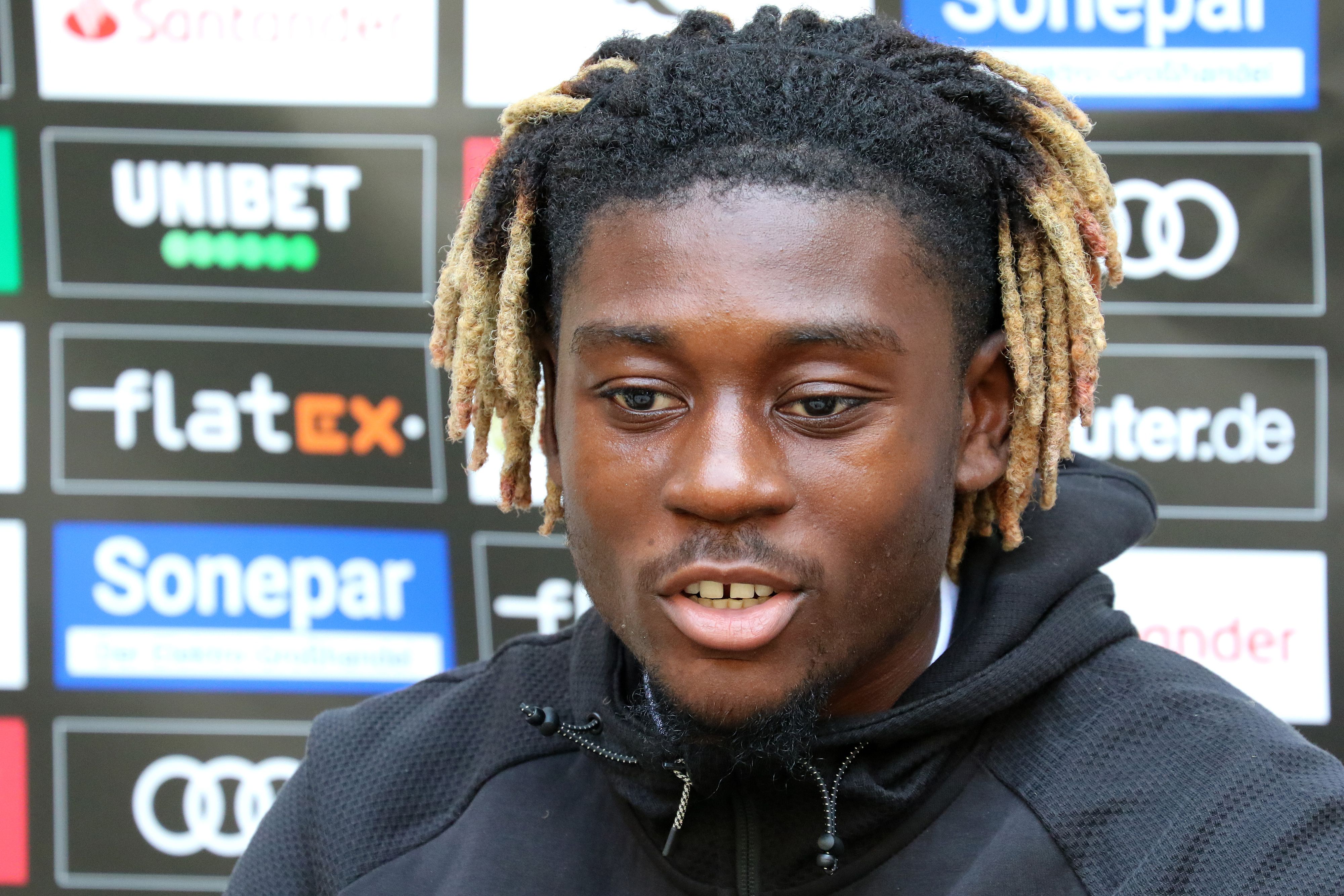 Gladbachs Neuzugang Manu Koné stellt sich in einer Medienrunde im Trainingslager in Harsewinkel-Marienfeld den Fragen der anwesenden Journalisten. Er schaut dabei nachdenklich.