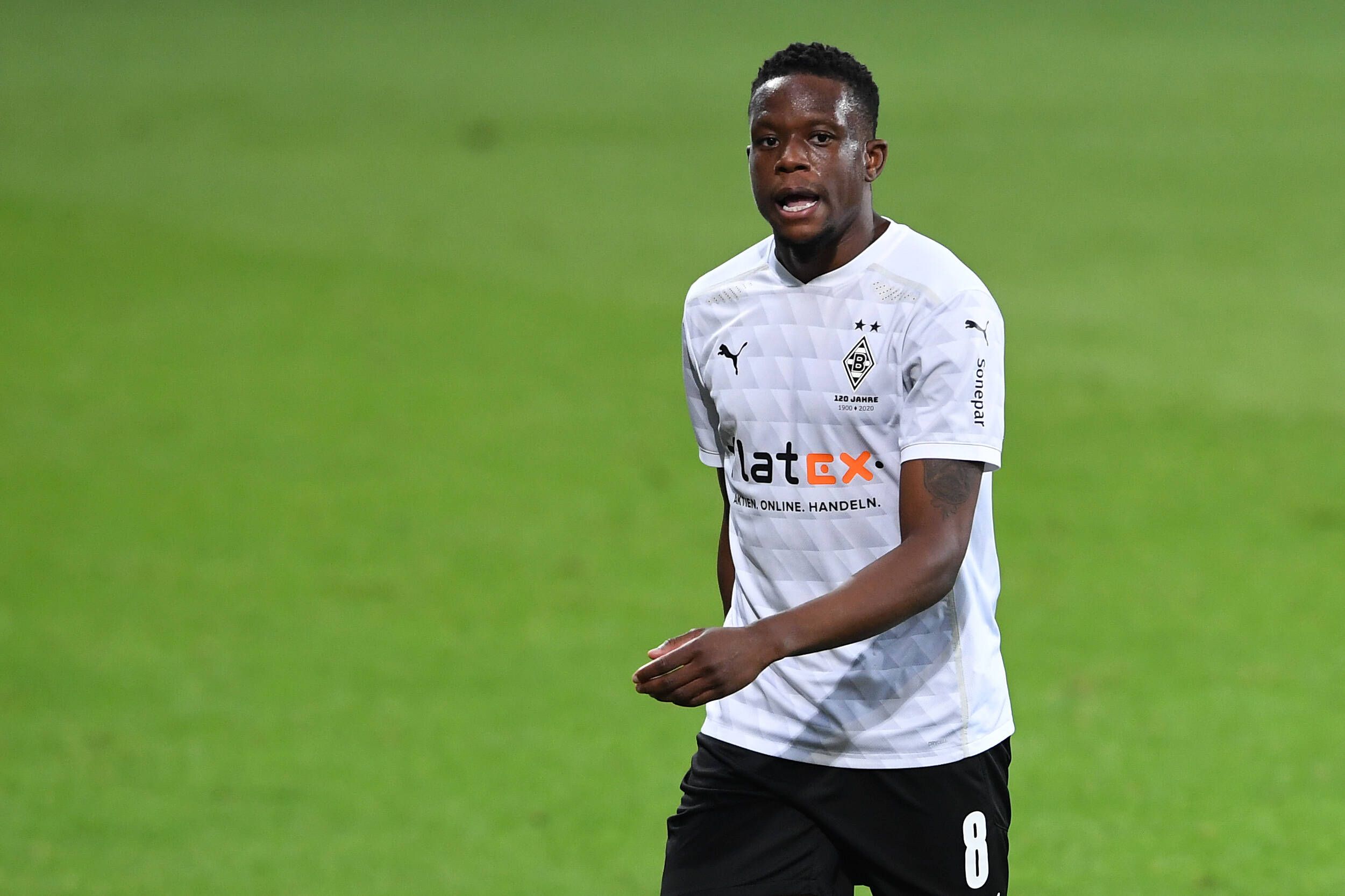 Denis Zakaria läuft im weißen Gladbach-Trikot über den Fußballplatz, er schaut angestrengt.