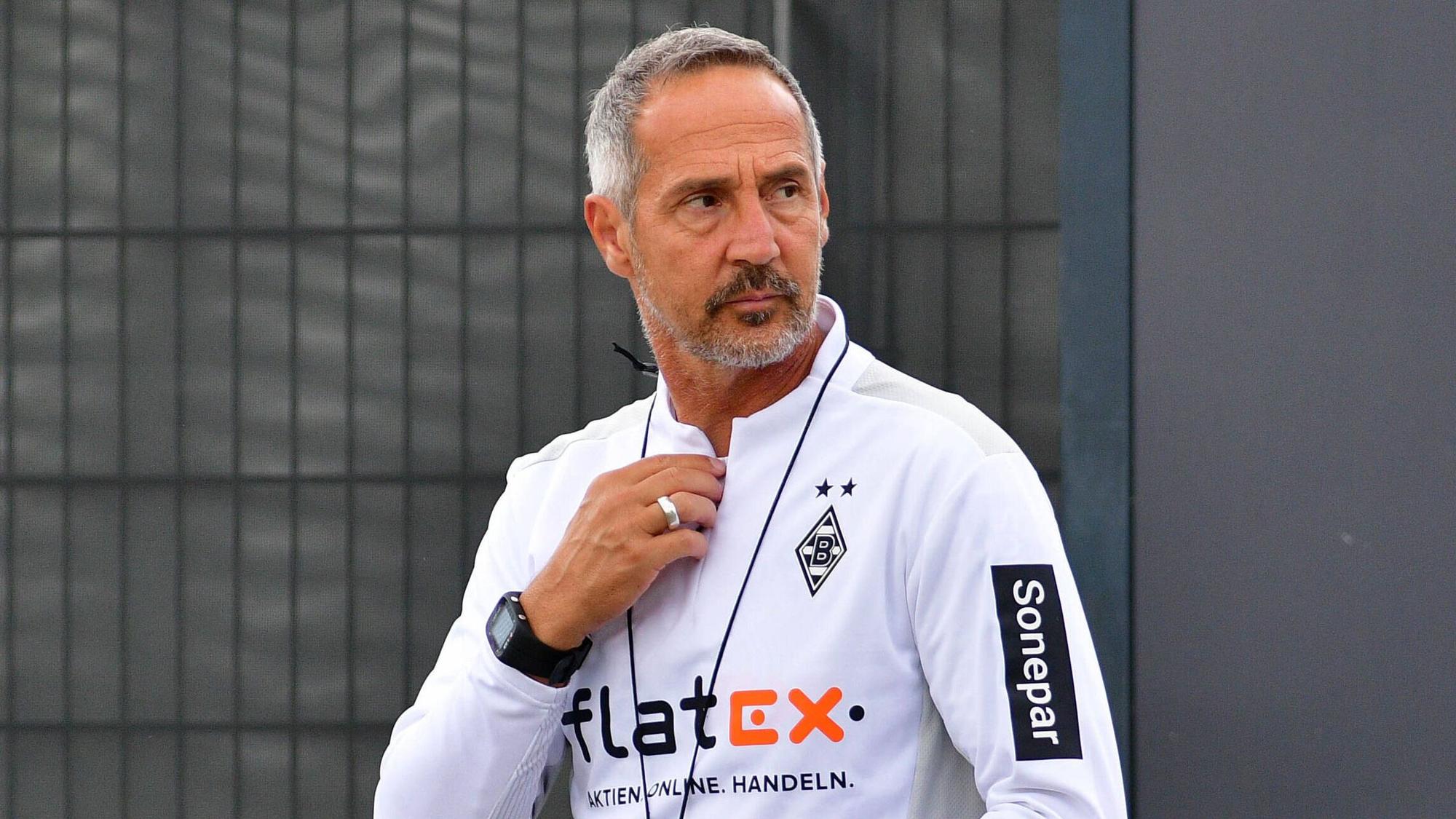 Gladbachs neuer Cheftrainer Adi Hütter betritt das Trainingsgelände im Borussia-Park, er fasst sich dabei mit der rechten Hand an den Hals.
