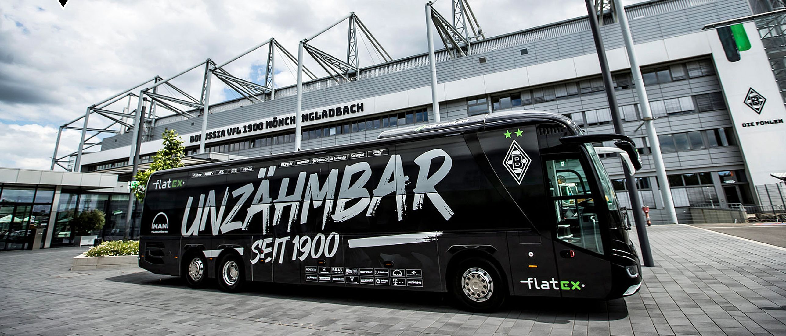 Fußball-Bundesligist Borussia Mönchengladbach fährt zu den Auswärtsspielen nun mit einem neuen Mannschaftsbus. Auf diesem steht unter anderem geschrieben: „Unzähmbar seit 1900“.