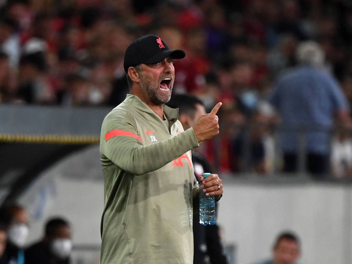 Jürgen Klopp, Trainer des englischen Top-Klubs FC Liverpool, brüllt bei einem Testspiel gegen Hertha BSC in Innsbruck am 29. Juli 2021 Anweisungen auf das Spielfeld. Mit dem rechten Arm gestikuliert er, in der linken Hand hält er derweil eine Getränkeflasche.