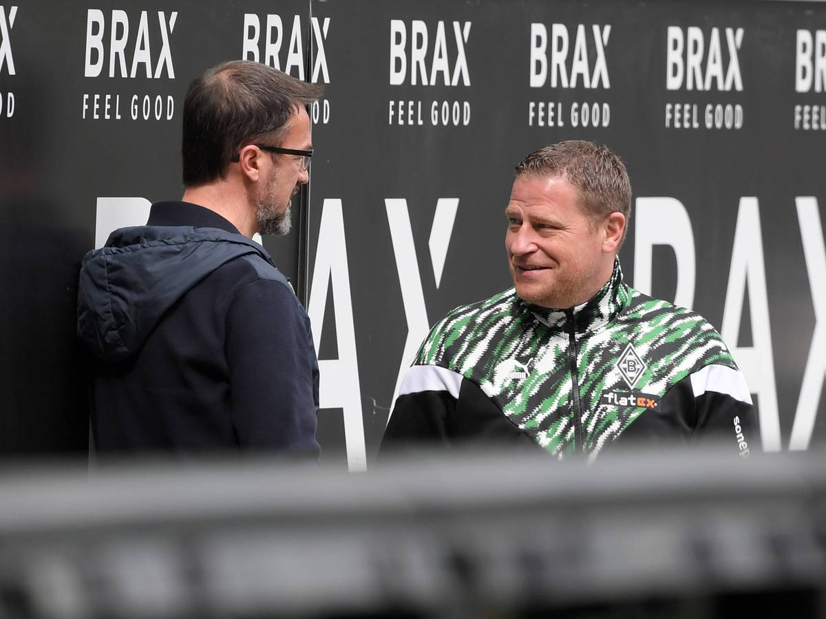 Gladbachs Manager Max Eberl (r.) unterhält sich am 17. April 2021 im Borussia-Park am Spielfeldrand mit Fredi Bobic (l.). Beide lächeln dabei.