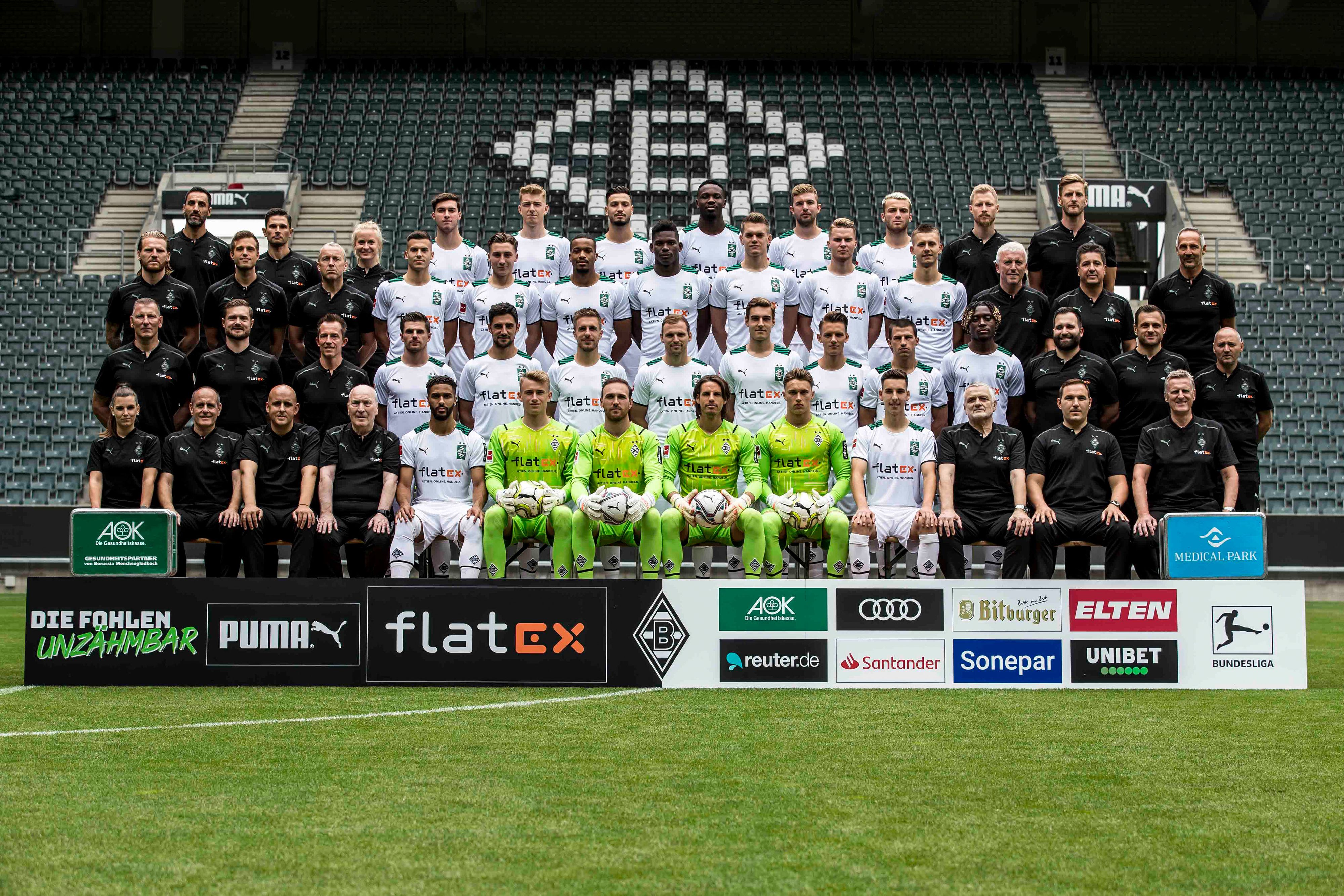 Fußball-Bundesligist Borussia Mönchengladbach hat am Sonntag, 1. August 2021, die Fohlen-Elf zum neuen Mannschafts-Foto zusammenkommen lassen. Insgesamt 51 Personen sind darauf zu sehen. Die Aufnahme ist im Borussia-Borussia-Park gemacht worden. Die Spieler tragen weiße Trikots, die Torhüter neongelbe. Das Betreuer- und Trainer-Team trägt hingegen schwarze Trainingsmonturen des Ausrüsters Puma.