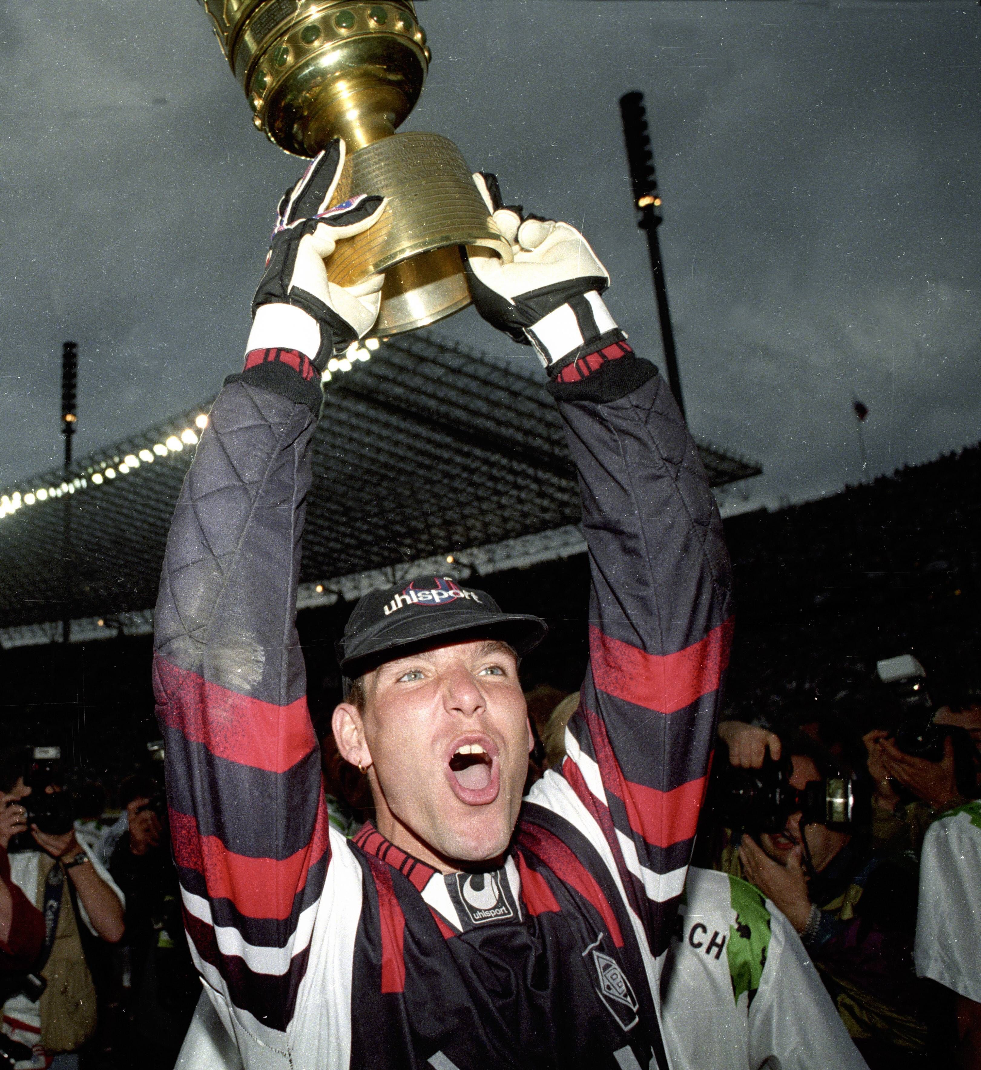 Torhüter Uwe Kamps bejubelt am 24. Juni 1995 den Pokalgewinn mit Borussia Mönchengladbach. Er hält den Pokal in den Armen und schreibt seine Freude herraus.