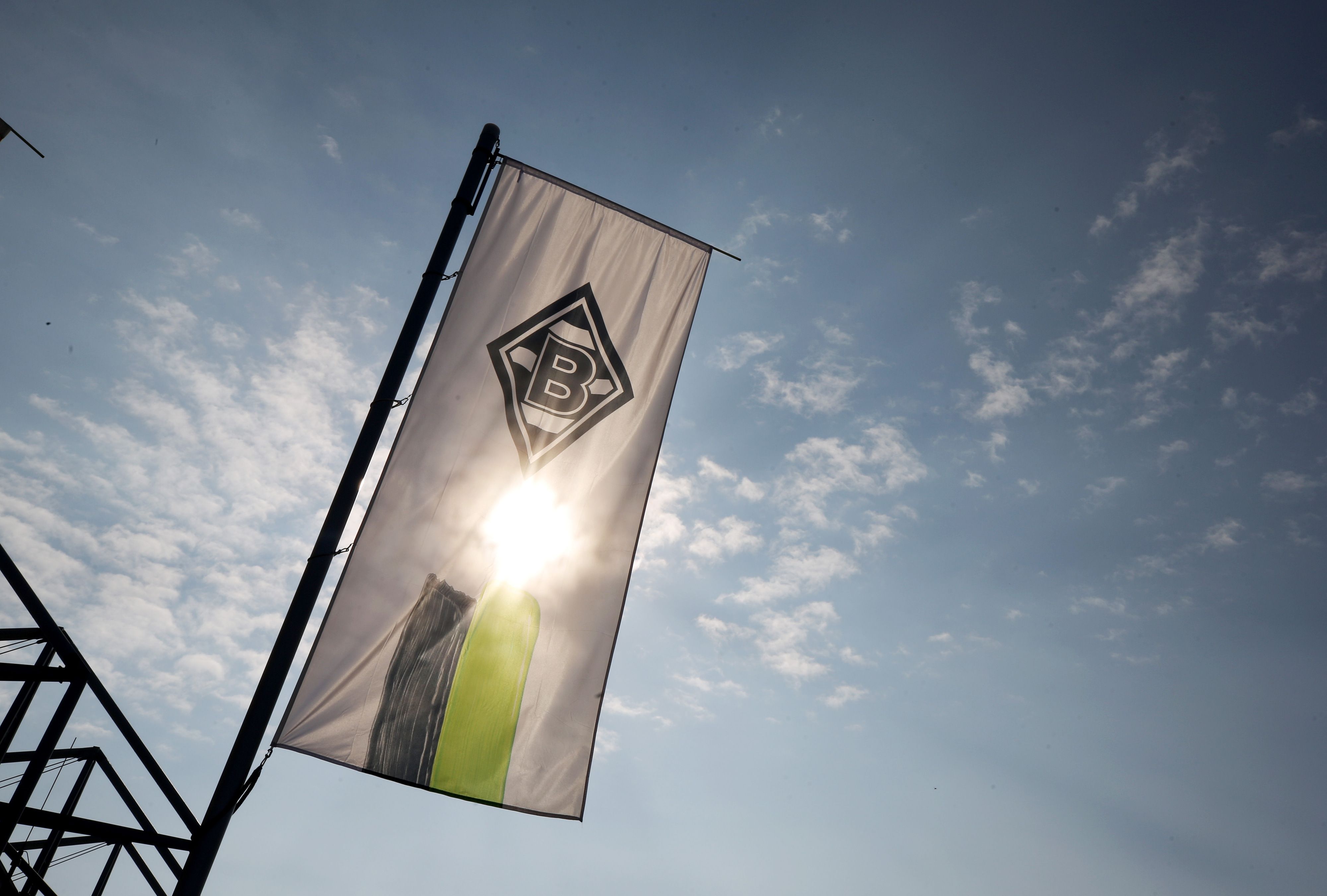 Die Vereinsfahne von Borussia Mönchengladbach weht vor der Sonne.