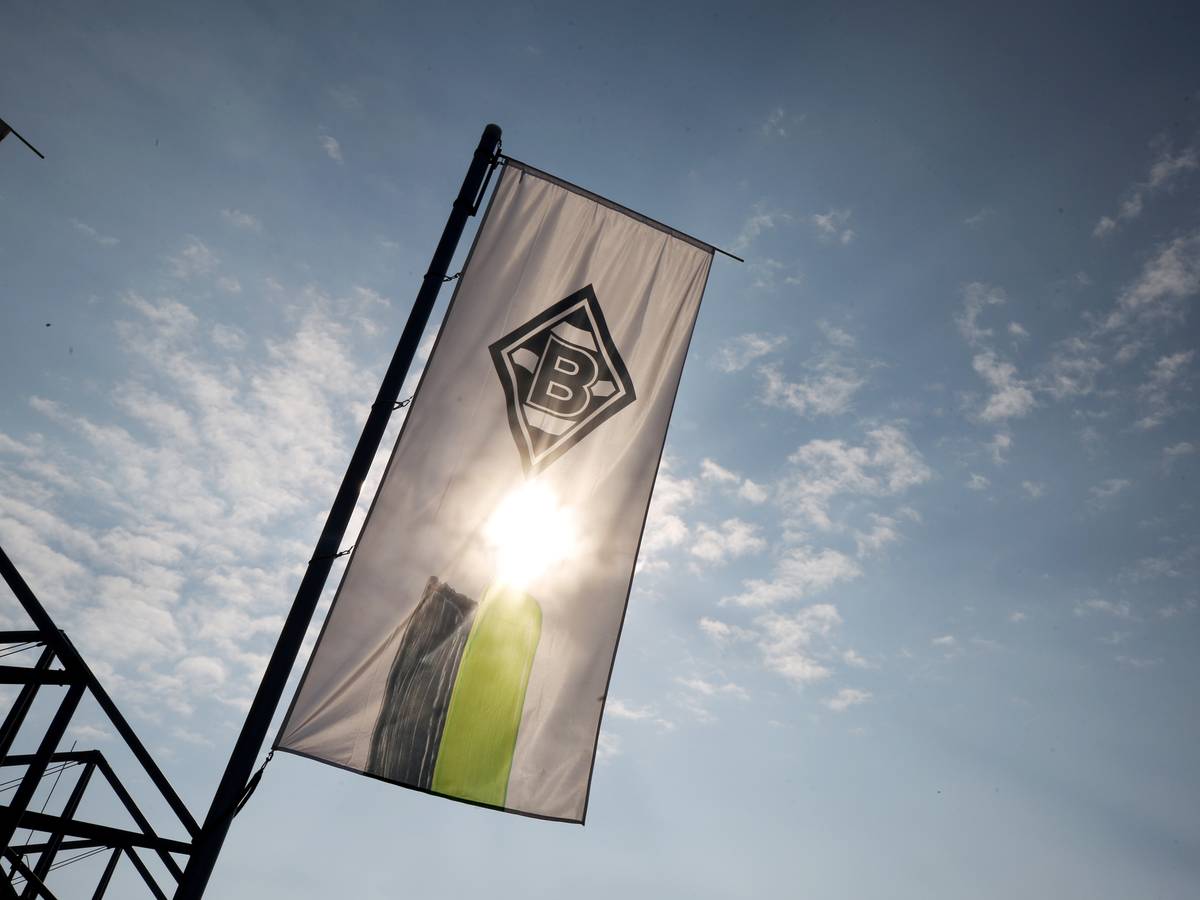 Die Vereinsfahne von Borussia Mönchengladbach weht vor der Sonne.
