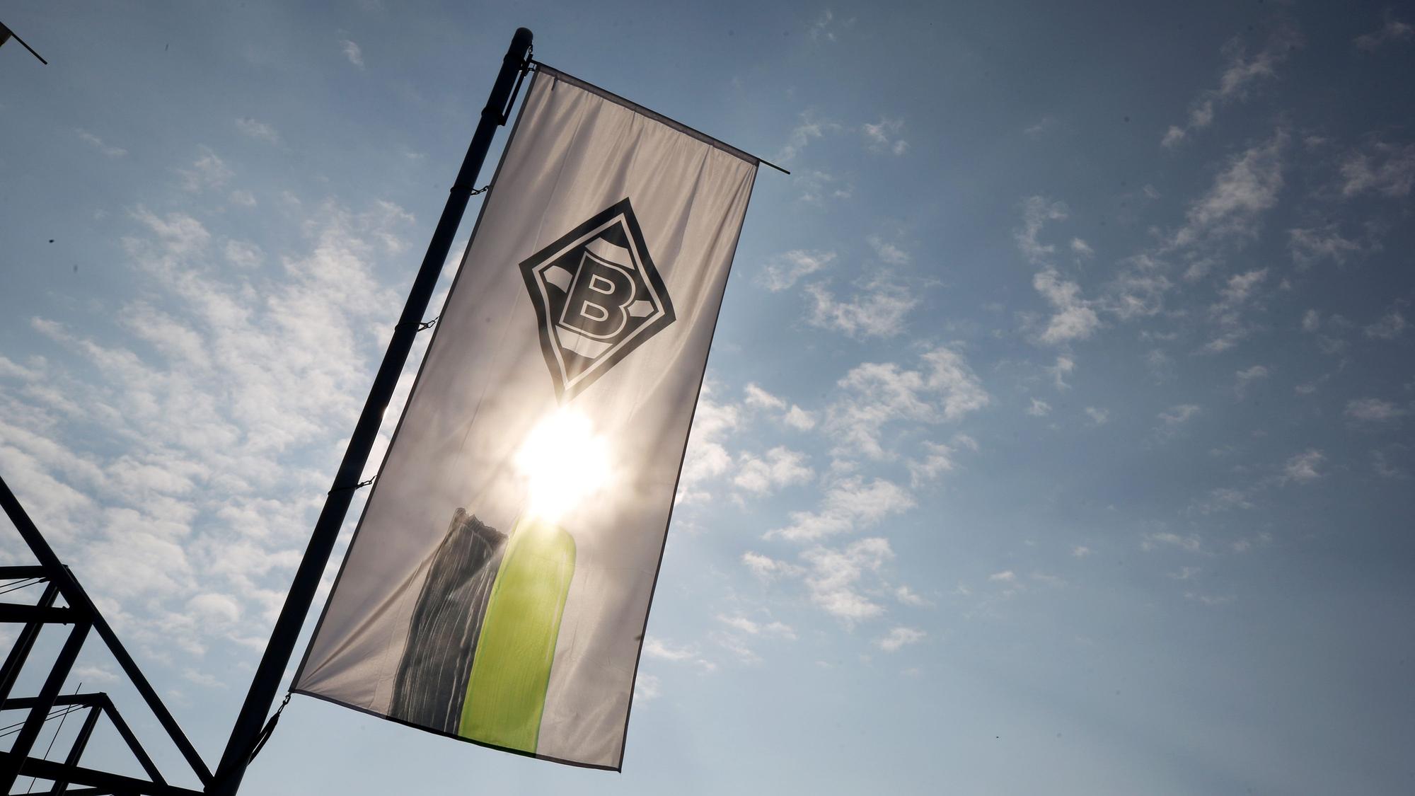Die Vereinsfahne von Borussia Mönchengladbach weht vor der Sonne.