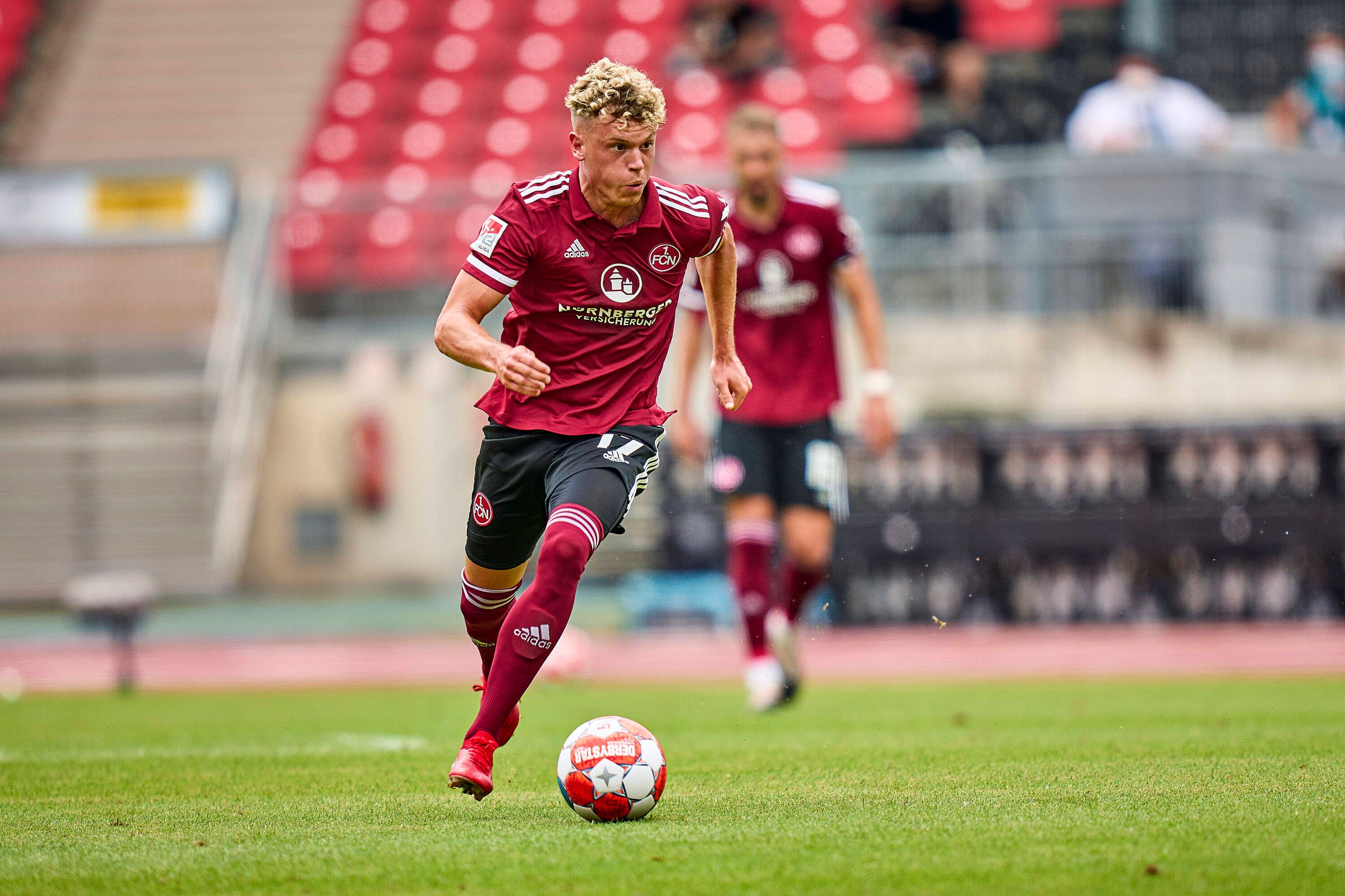 Der Nürnberger Offensivspieler Robin Hack kontrolliert den Ball, derweil schaut er, welchen Mitspieler er in Szene setzen könnte.