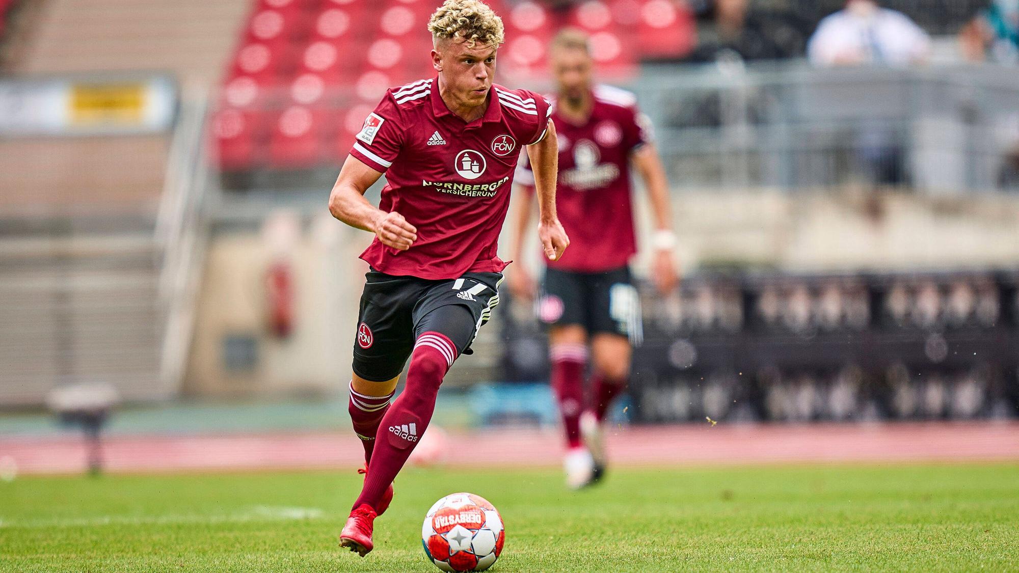 Der Nürnberger Offensivspieler Robin Hack kontrolliert den Ball, derweil schaut er, welchen Mitspieler er in Szene setzen könnte.