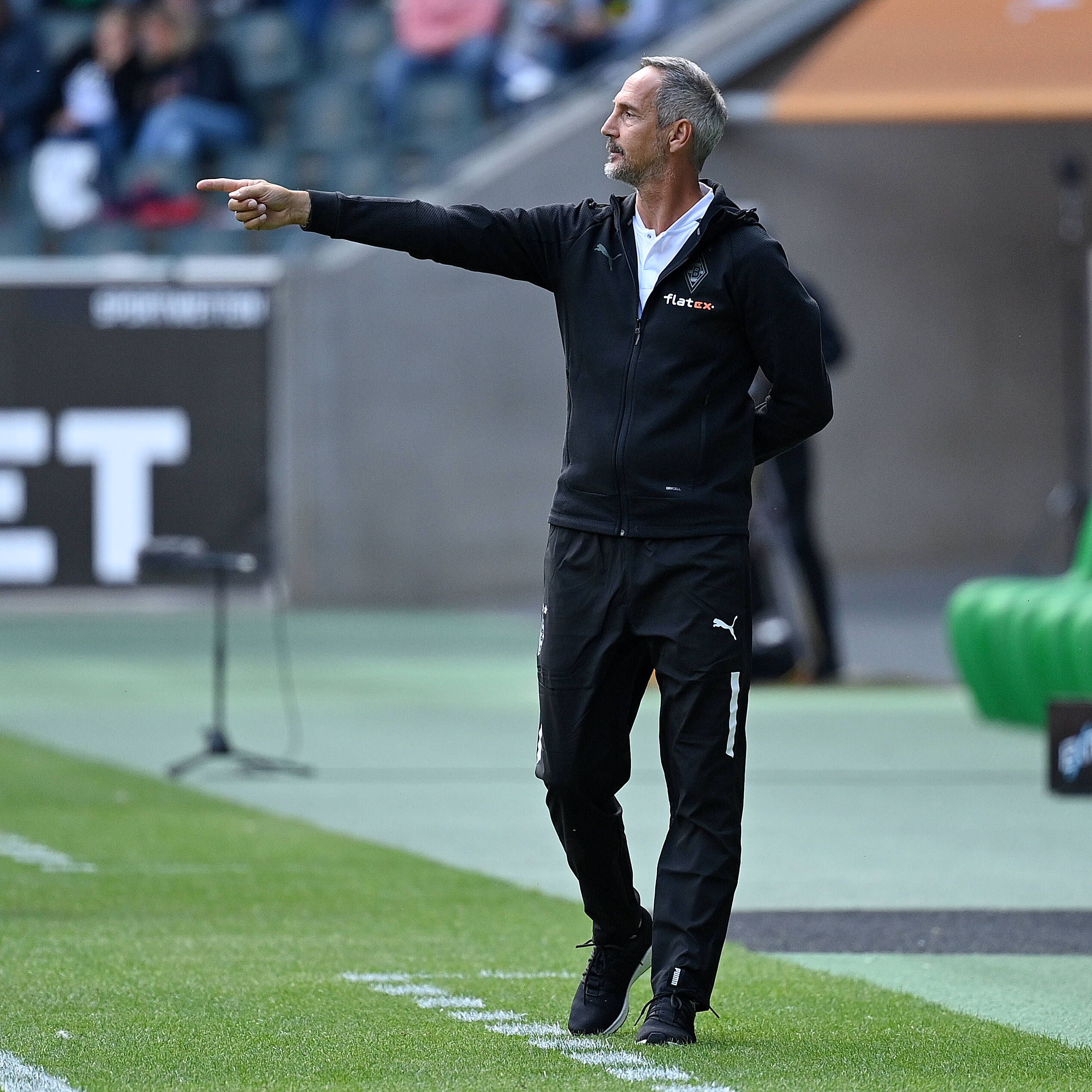Adi Hütter steht mit ausgestrecktem Arm an der Seitenlinie im Testspiel der Gladbacher. Mit seinem Finger zeigt er ein Kommando an.