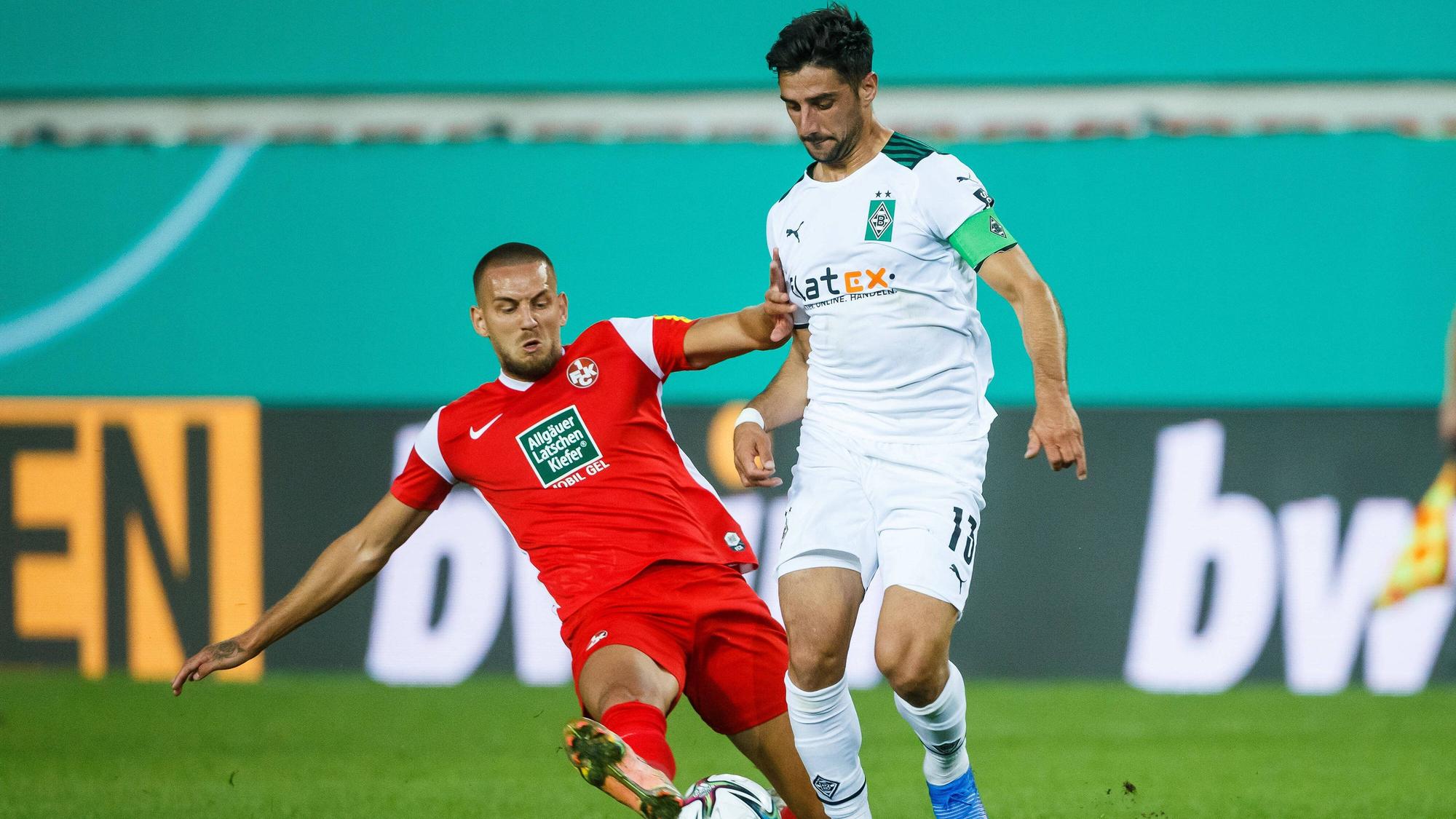 Rene Klingenburg (l.) vom 1.FC Kaiserslautern im Zweikampf mit Gladbachs Kapitän Lars Stindl (r.) beim Pokal-Duell am 9. August 2021 auf dem Betzenberg.